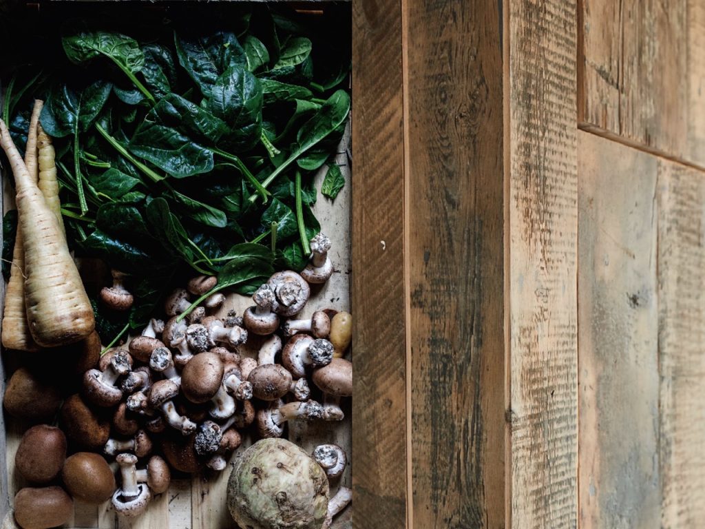 Fresh earth vegetables next to reclaimed pine wood cladding