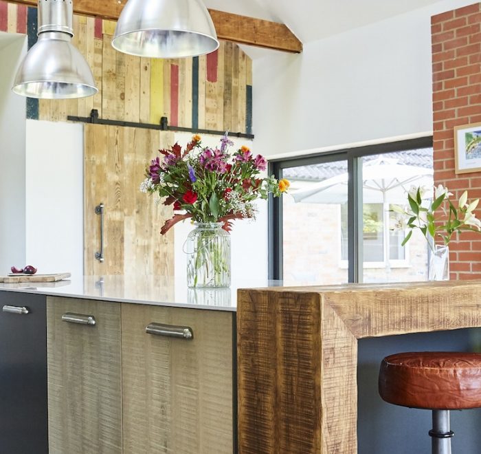 Rustic reclaimed kitchen island with brown leather stools