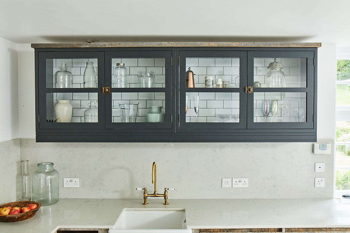 Pair of double door wall cabinets above ceramic sink with metro tiles