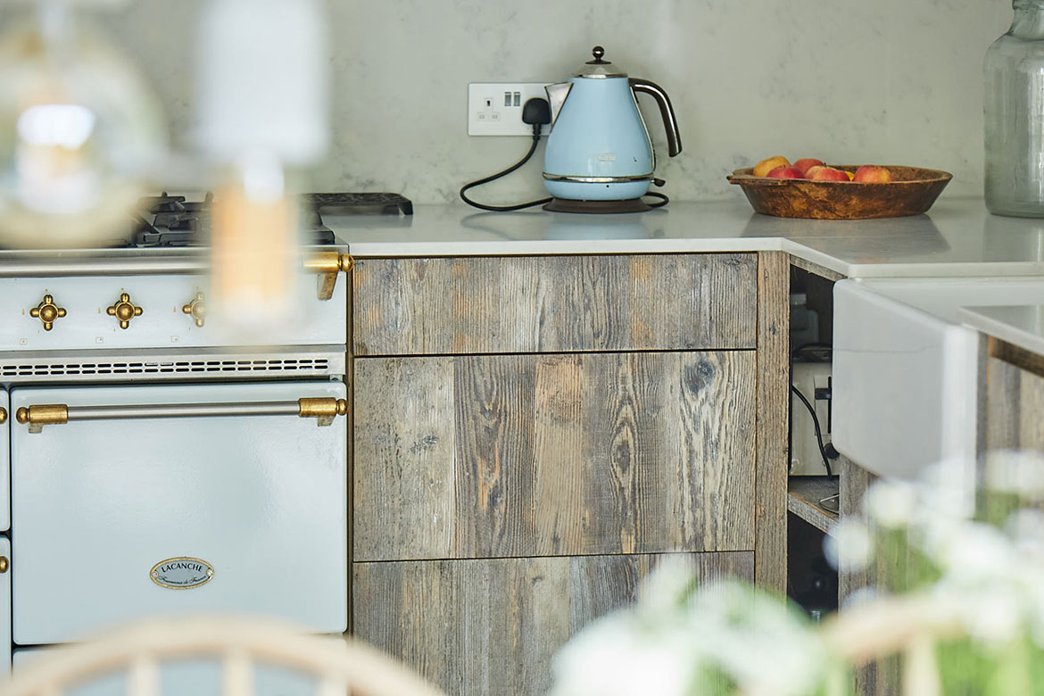 Light blue kettle sits on top of reclaimed rustic pine drawer stack