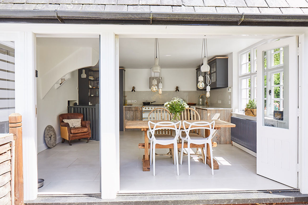 Philippe Starck white chairs with reclaimed wood kitchen and table