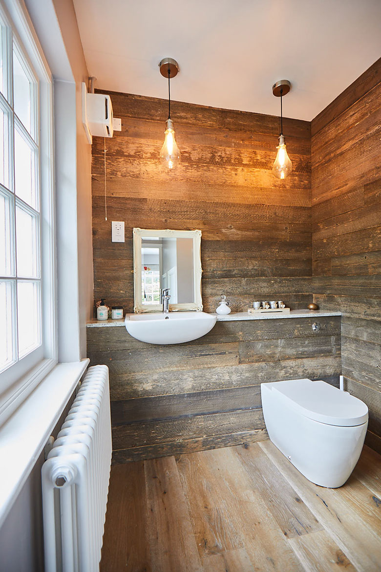 Wood cladded bathroom with floating sink and toilet
