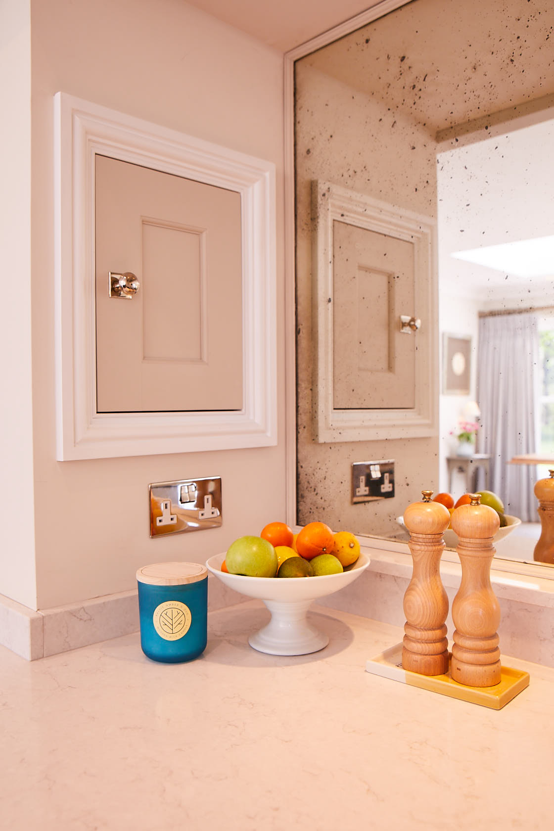 Small bespoke painted cabinet integrated in to false chimney breast with bowl of fruit in front