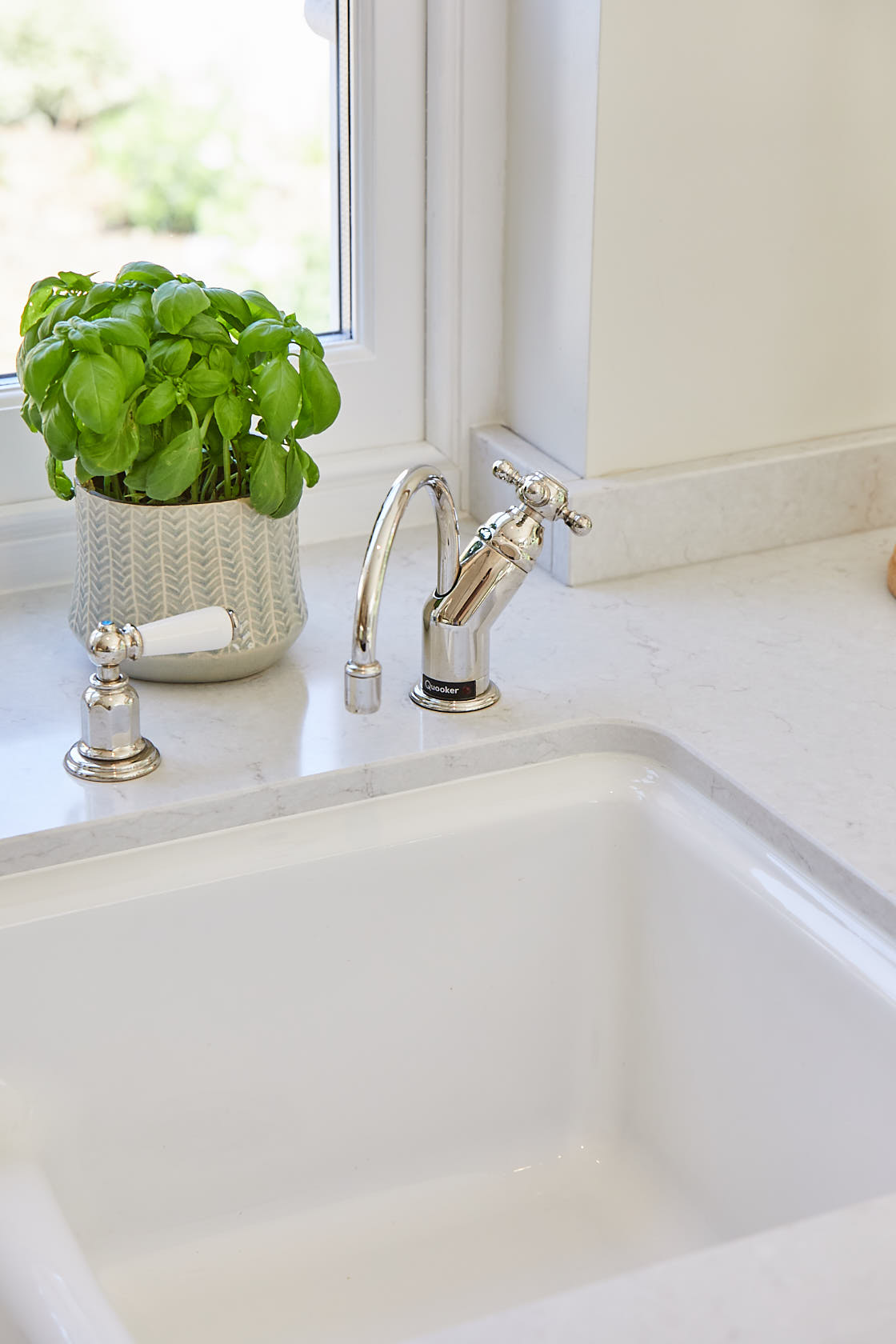 Quooker hot tap in chrome finish above single ceramic square sink