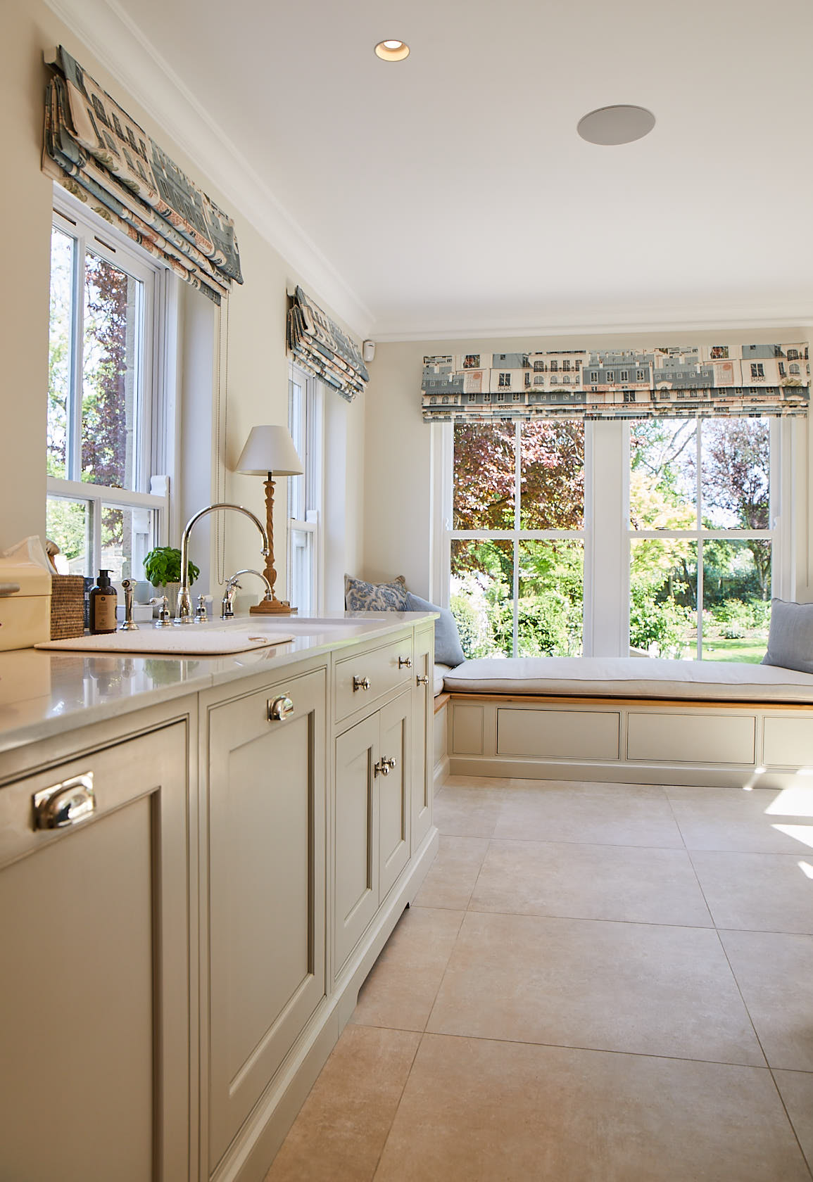 Traditional painted kitchen units with integrated ceramic sink and window seat