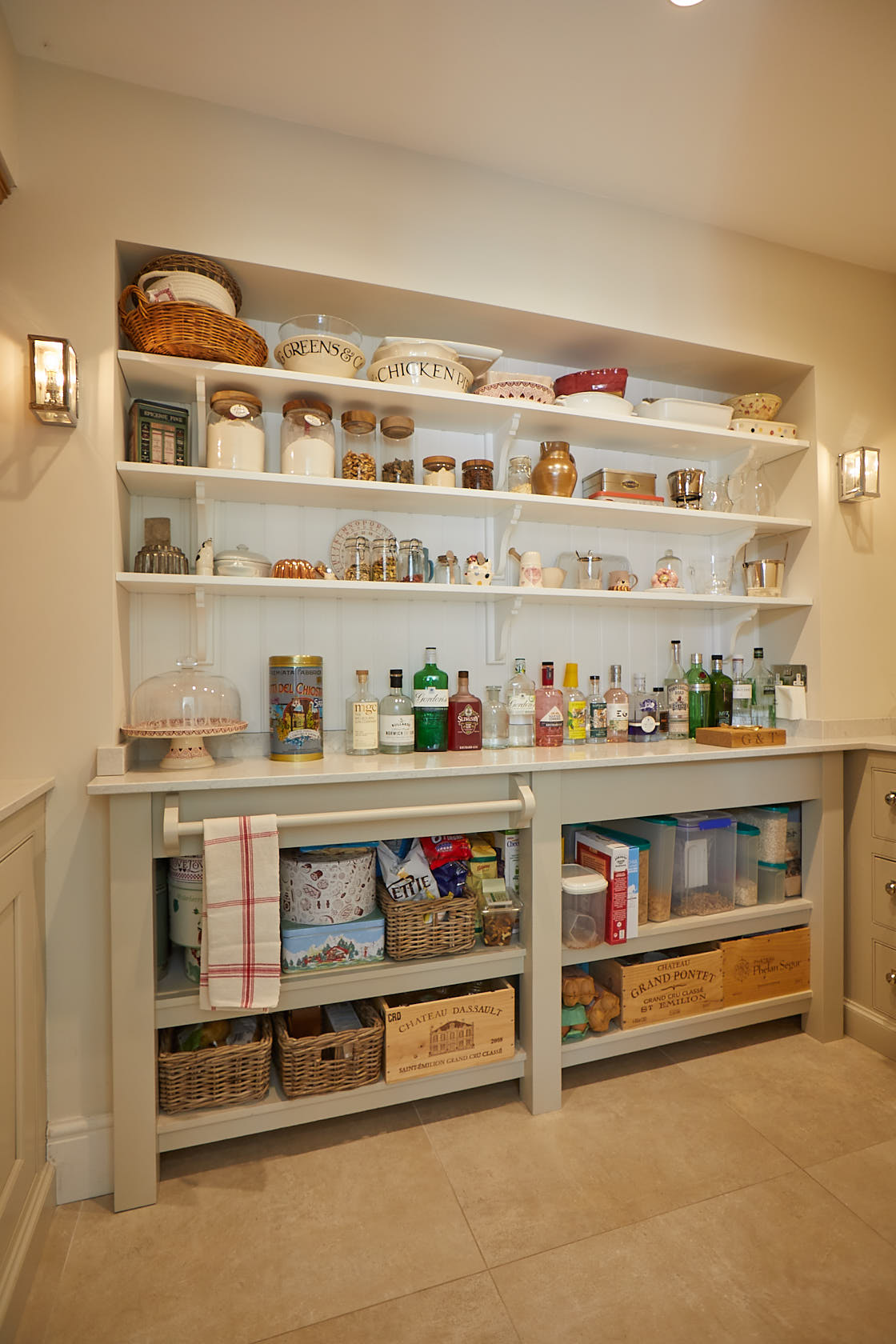 Pantry food storage on bespoke cream pained open shelves and pot board with white quartz top