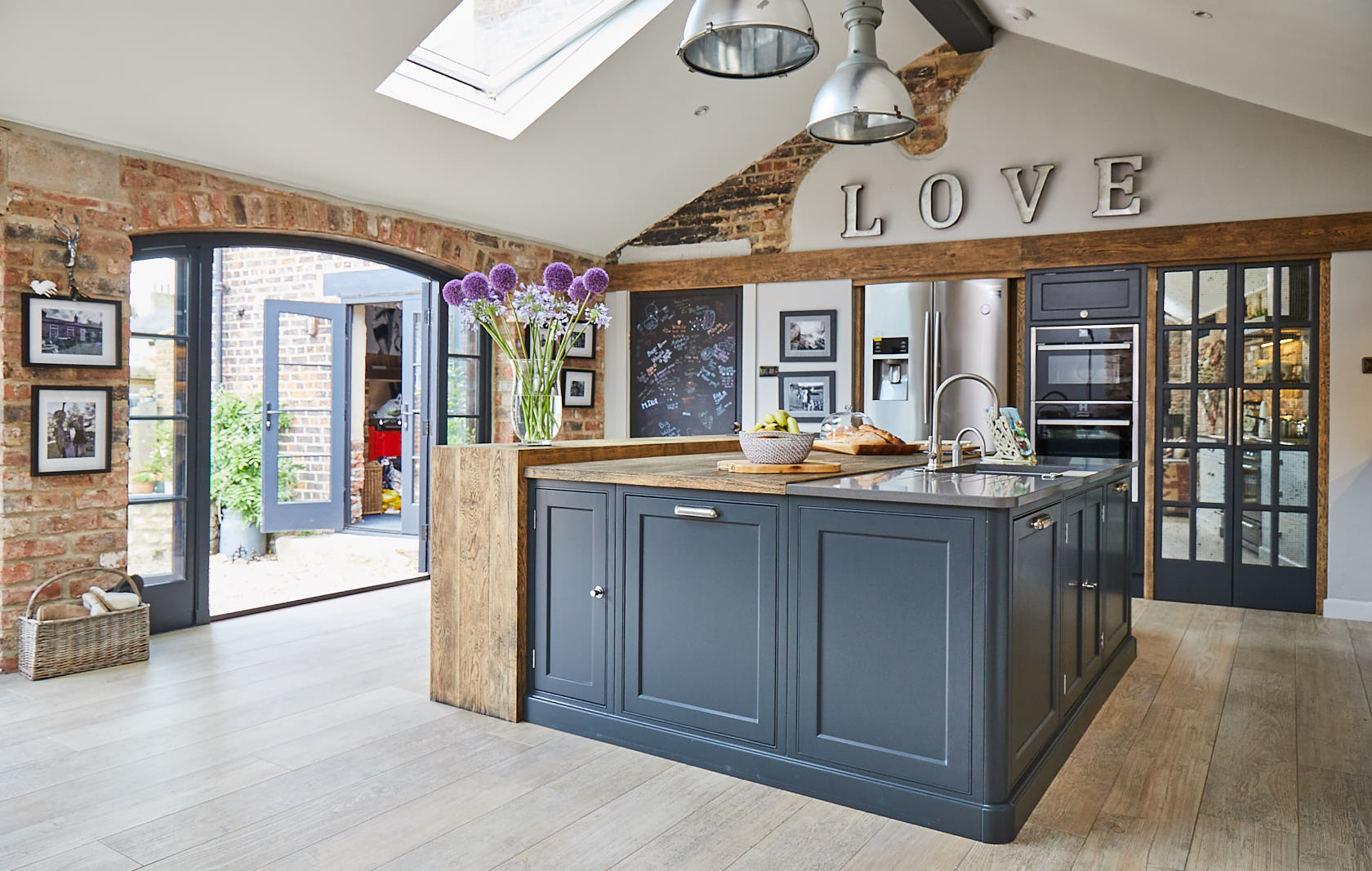 Painted Lamp Black shaker cabinets make up kitchen island with Caesarstone and oak worktop