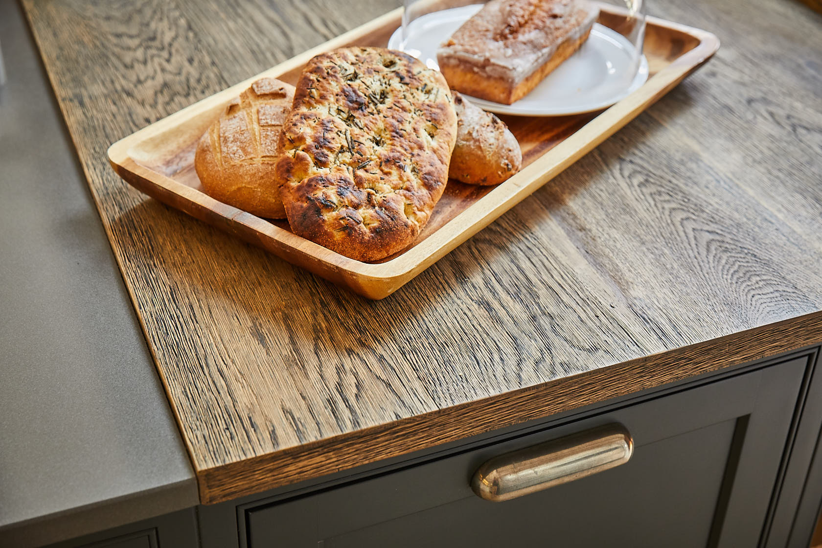 Fresh bread sits on engineered rustic oak wood worktop