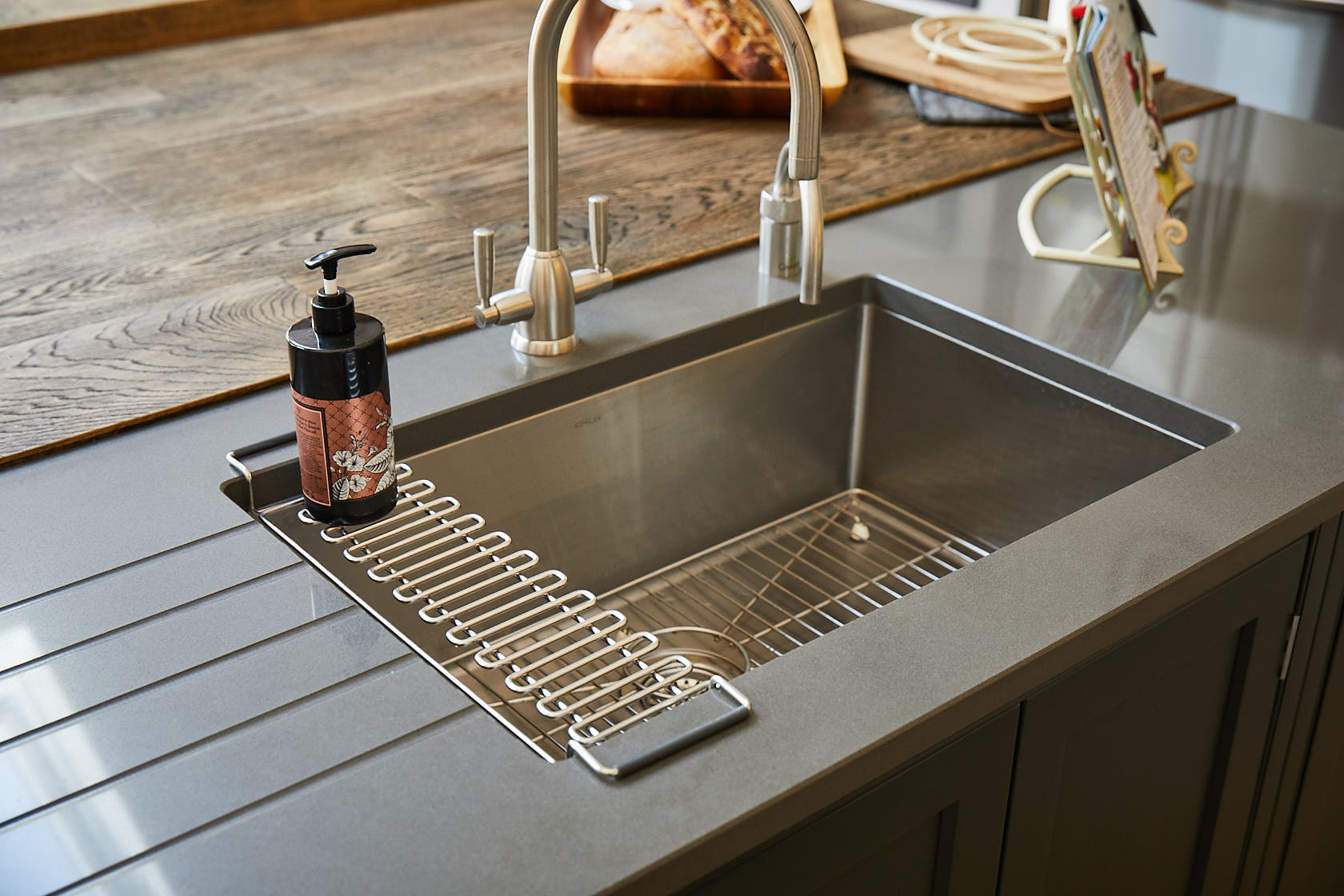 Brushed mono bloc tap above stainless steel Kholer sink with drainage grill accessory