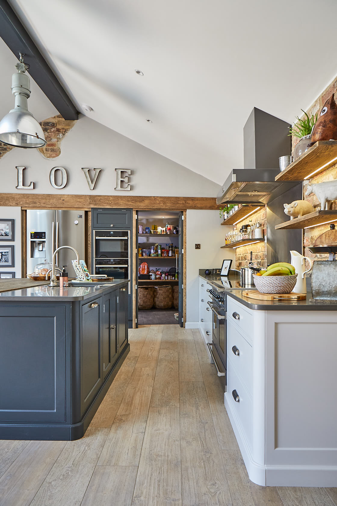 Hidden pantry room behind kitchen cabinet doors and rustic oak wood trim