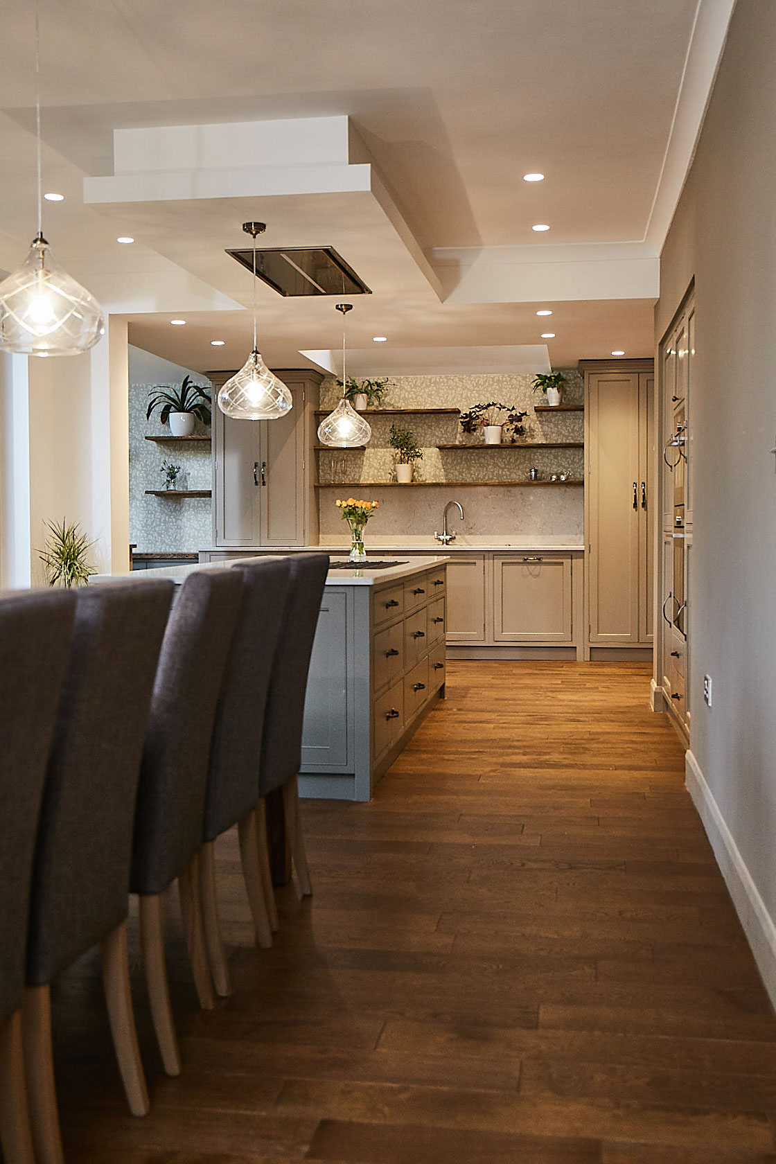 Upholstered chairs in open plan bespoke painted kitchen