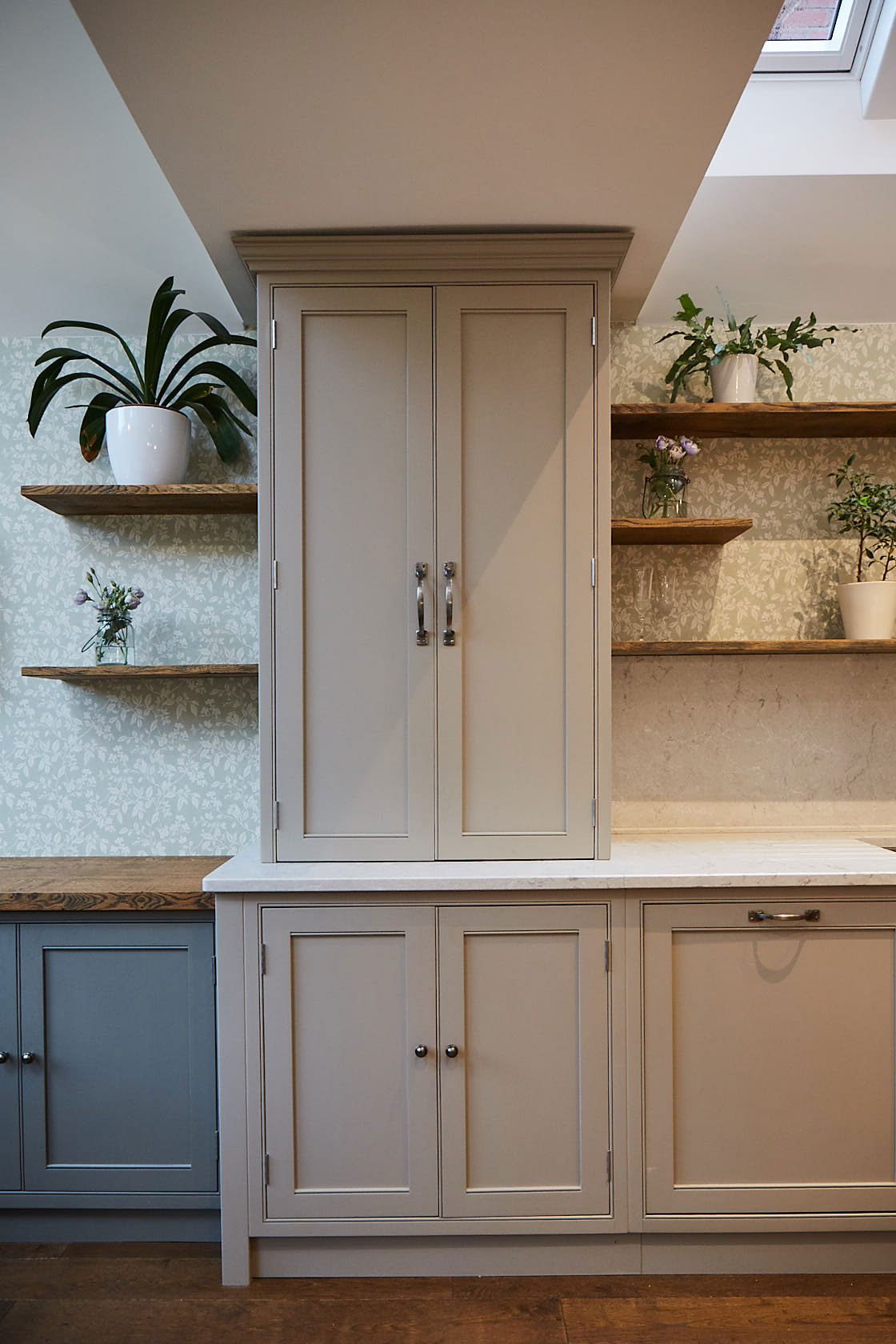 Wall unit sits on white worktop with open wood shelves left and right