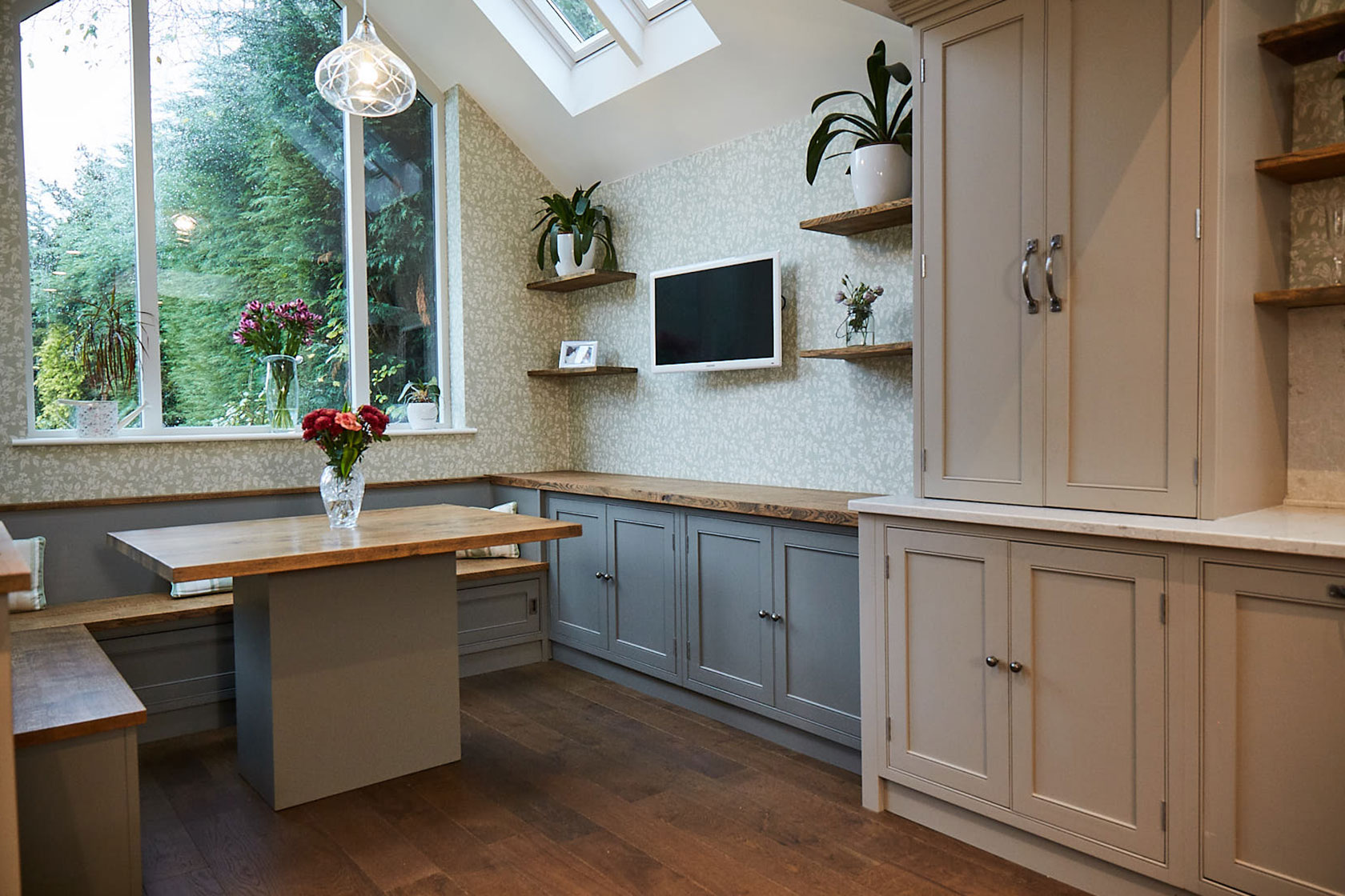 TV mounted on wall with double door storage cabinets below