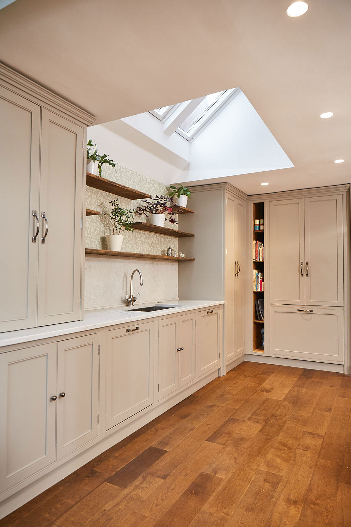 Reclaimed oak open shelves with plants above kitchen sink run