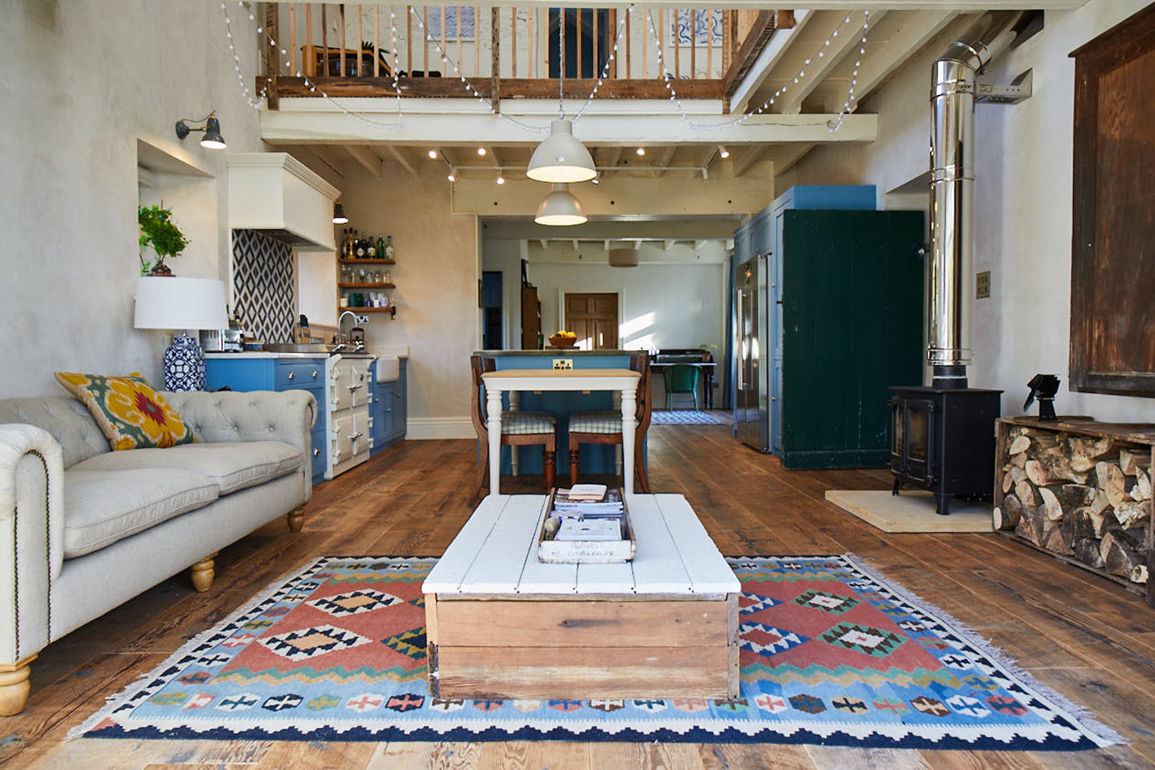 Reclaimed coffee table sits on large aztec rug with cream upholstered sofa