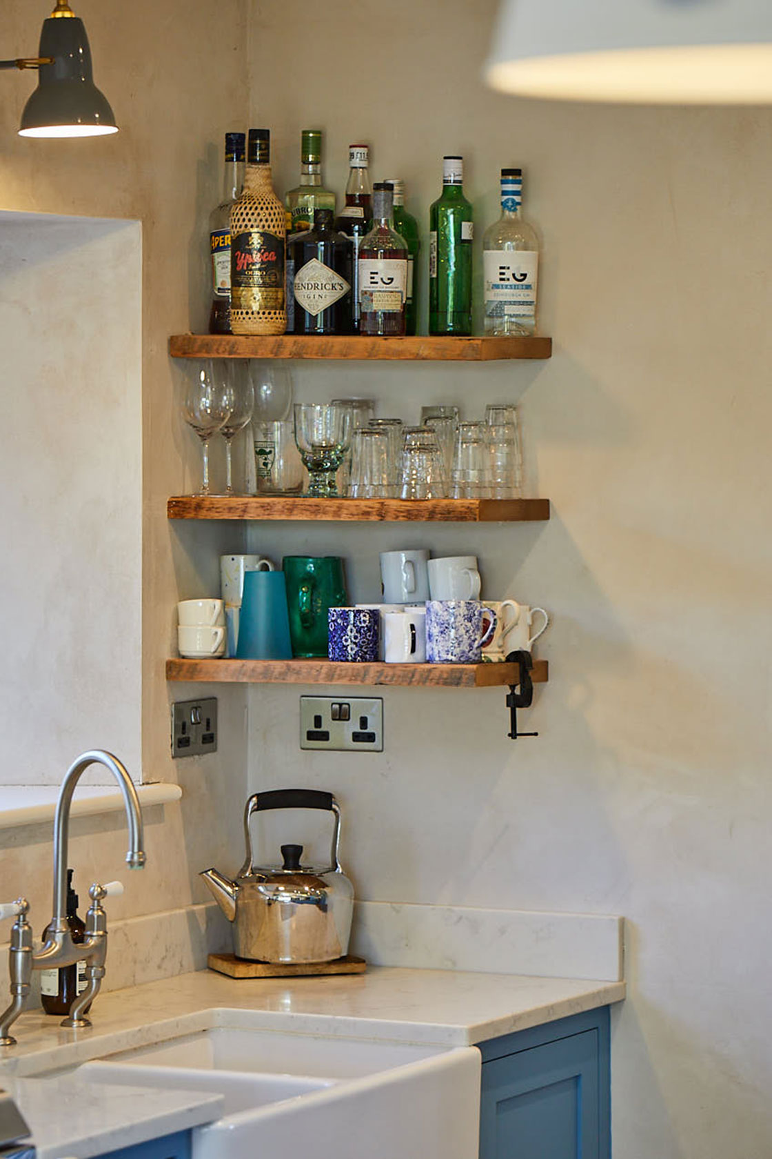 Spirits and condiments sit on reclaimed oak floating shelves