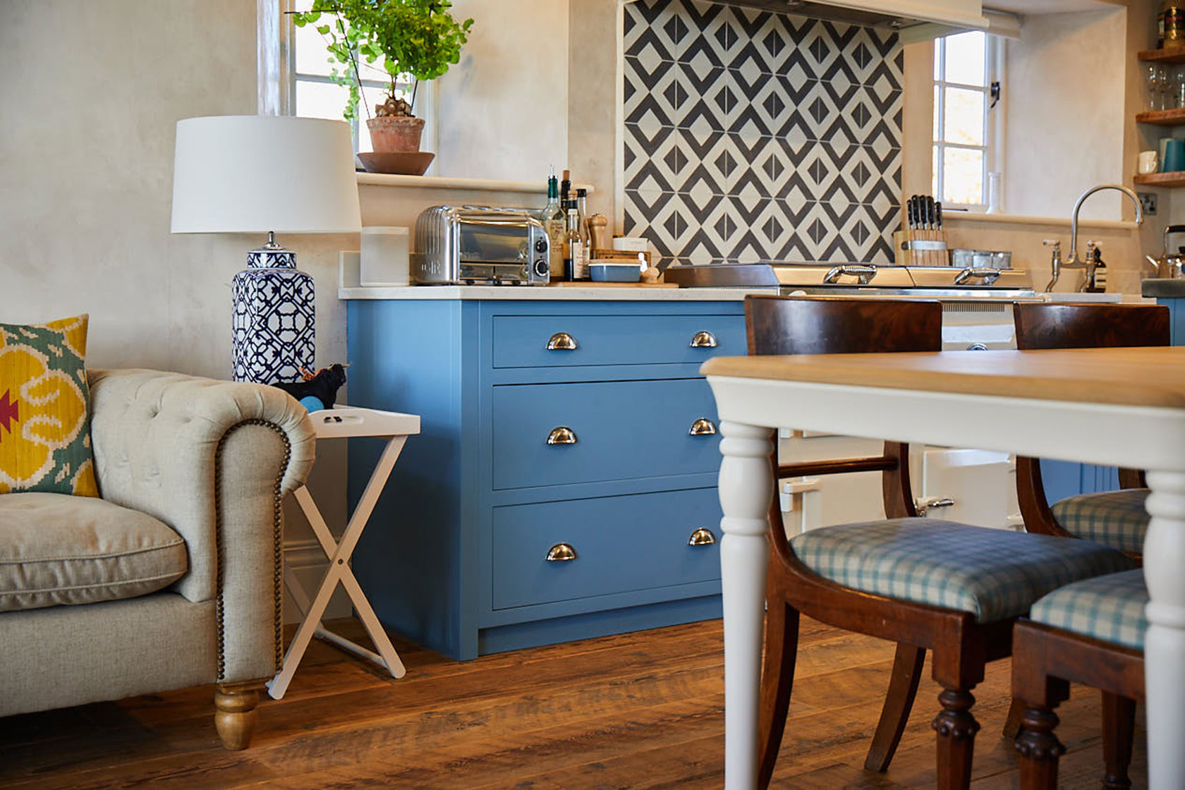 Light blue kitchen pan drawers with cream farmhouse table