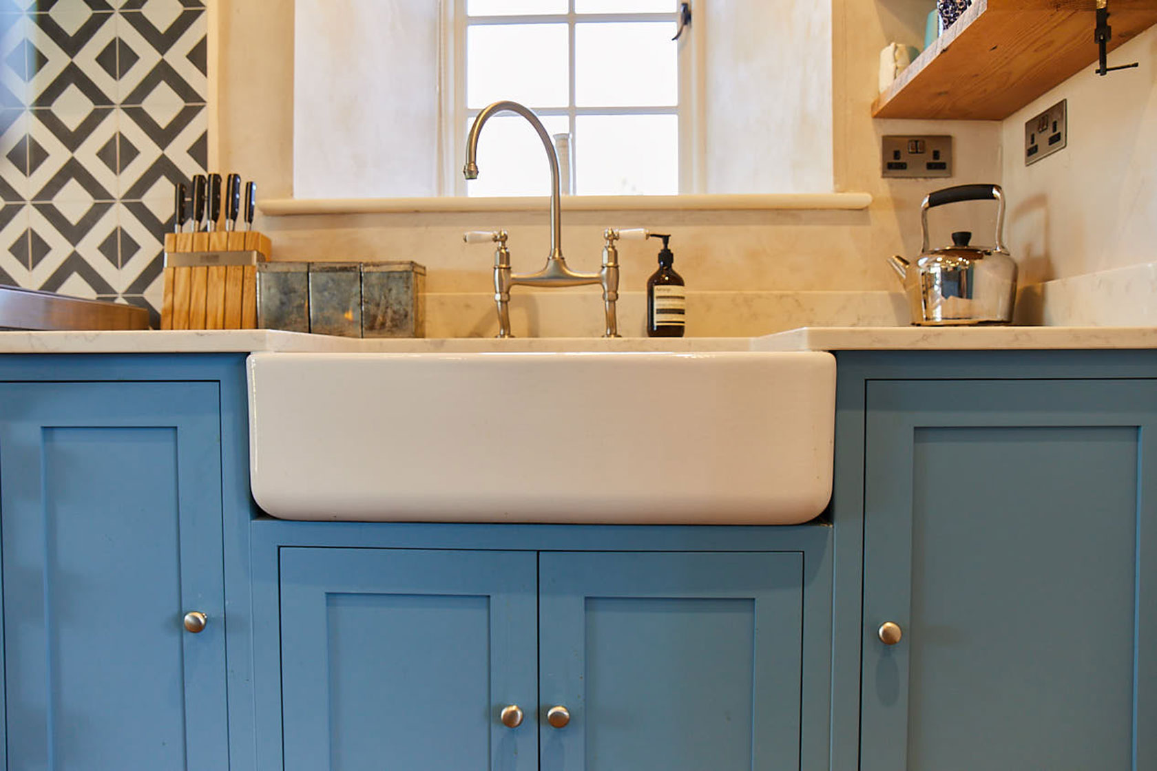 Double Belfast ceramic sink on light blue bespoke kitchen units