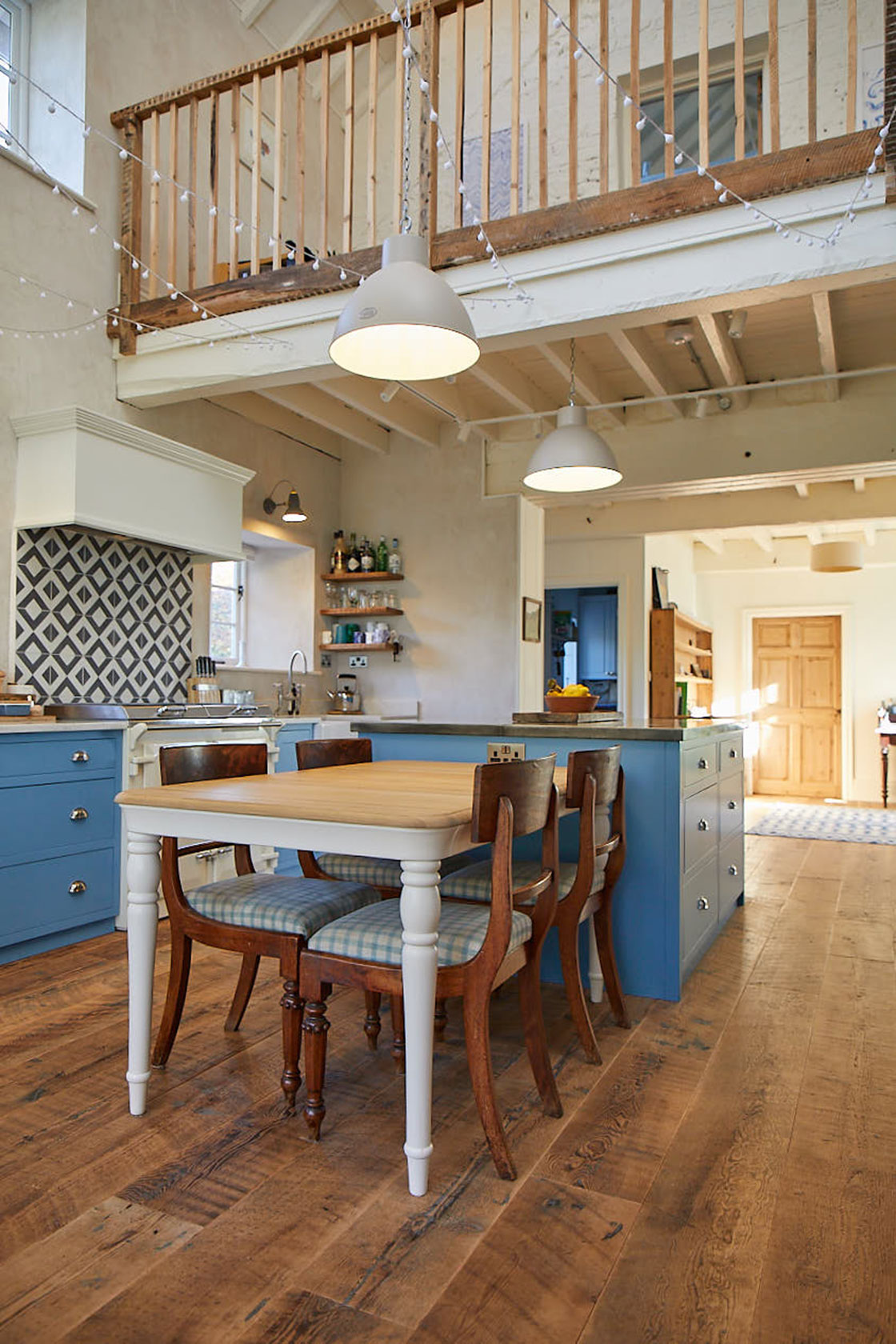 Painted farmhouse oak table next to light blue kitchen island