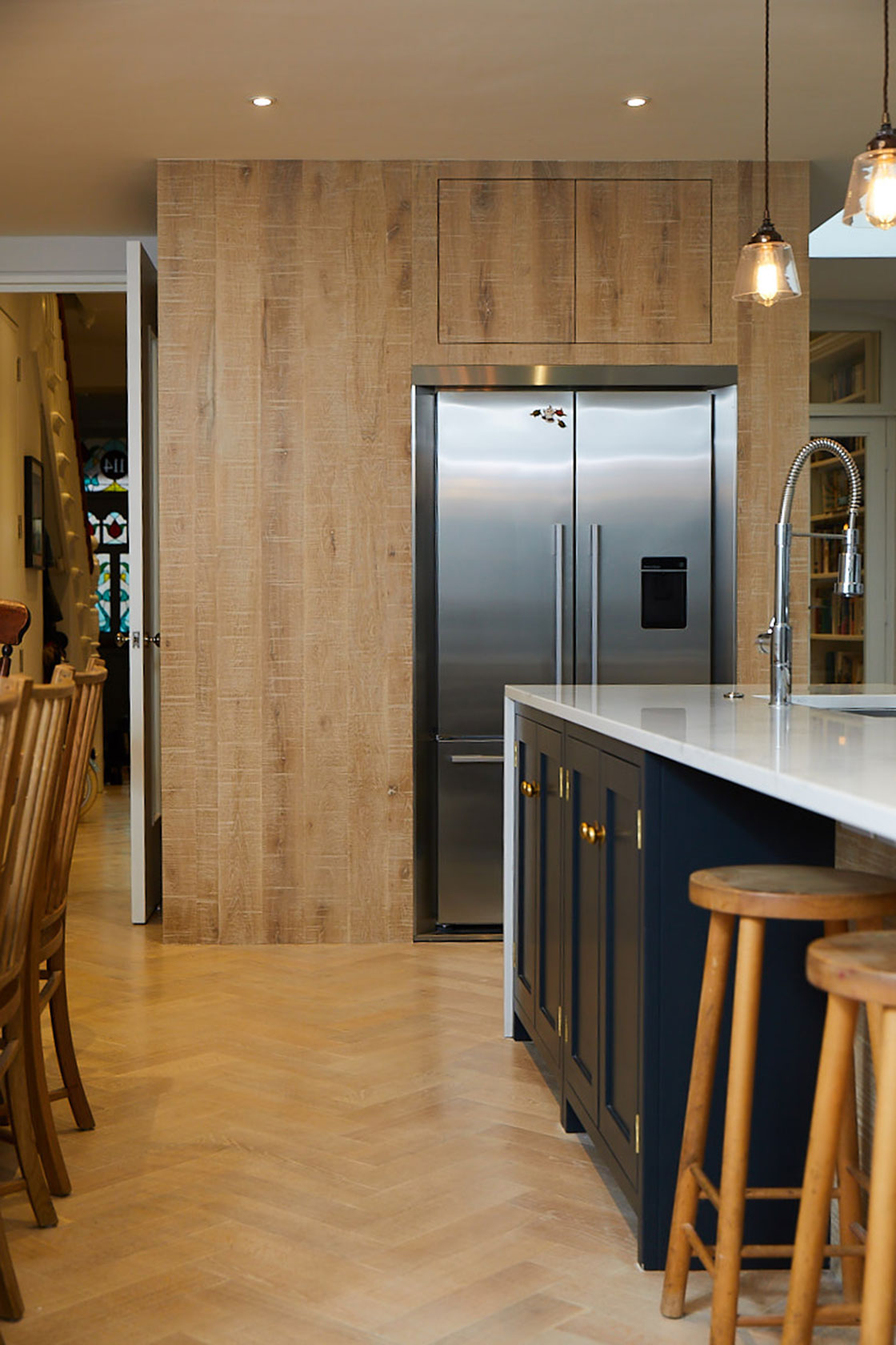 American Fisher & Paykel fridge freezer with surround in large limed oak kitchen units