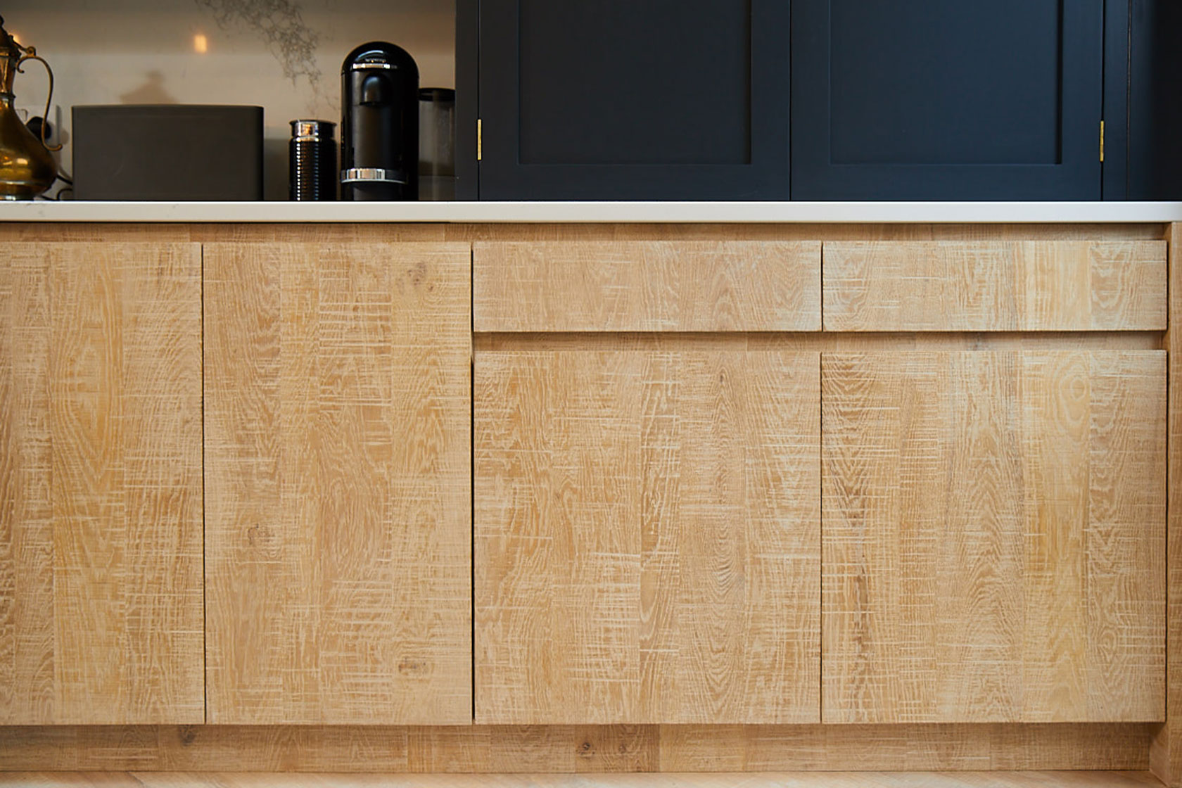 Limed oak kitchen base units with integrated bin for recycling and Caesarstone worktop