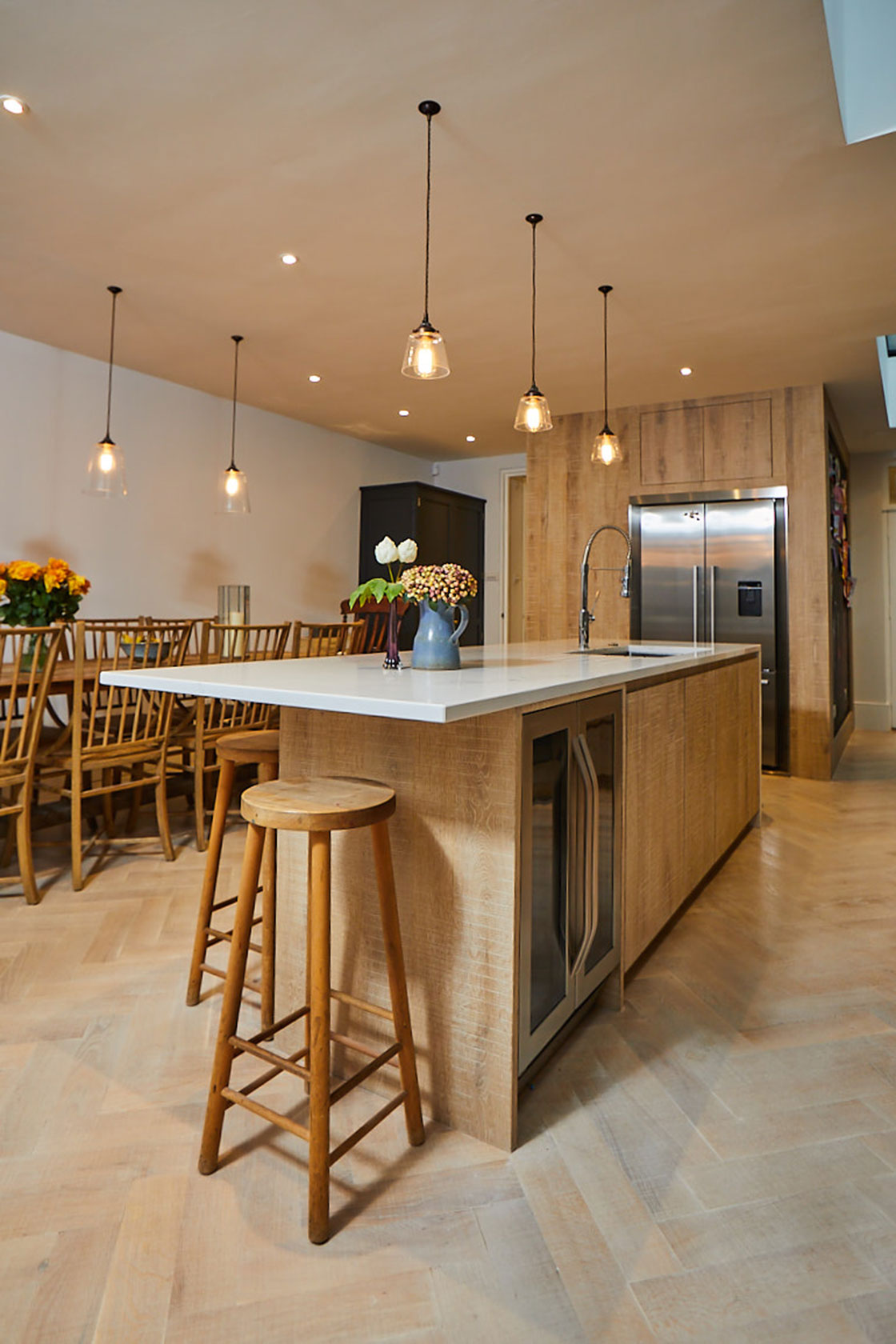 Oak breakfast bar stool sits under white Caesarstone worktop