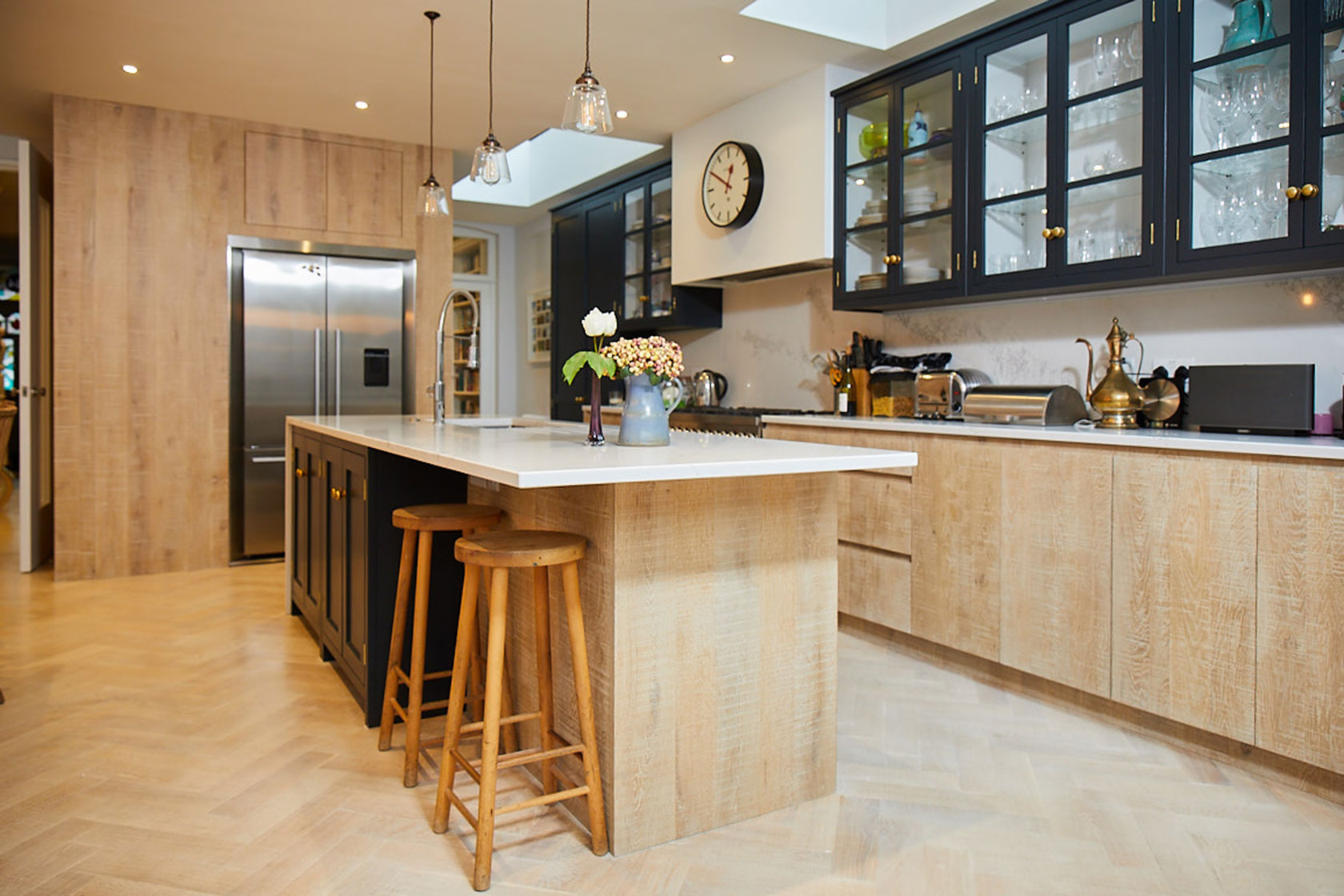 Bespoke kitchen with dark blue traditional cabinets and limed oak slab doors in island