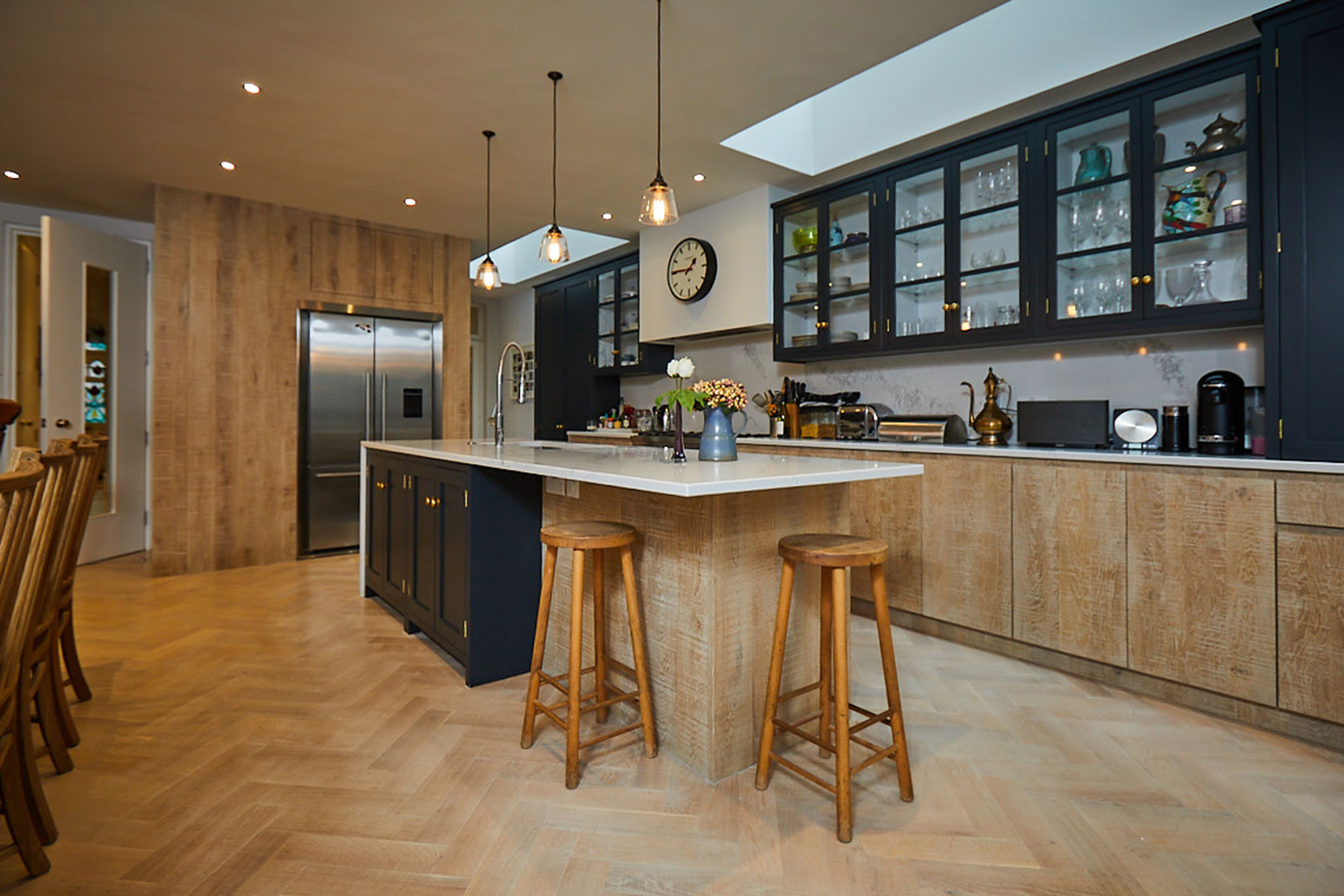 Kitchen island and bespoke range run with parquet wood floor boards