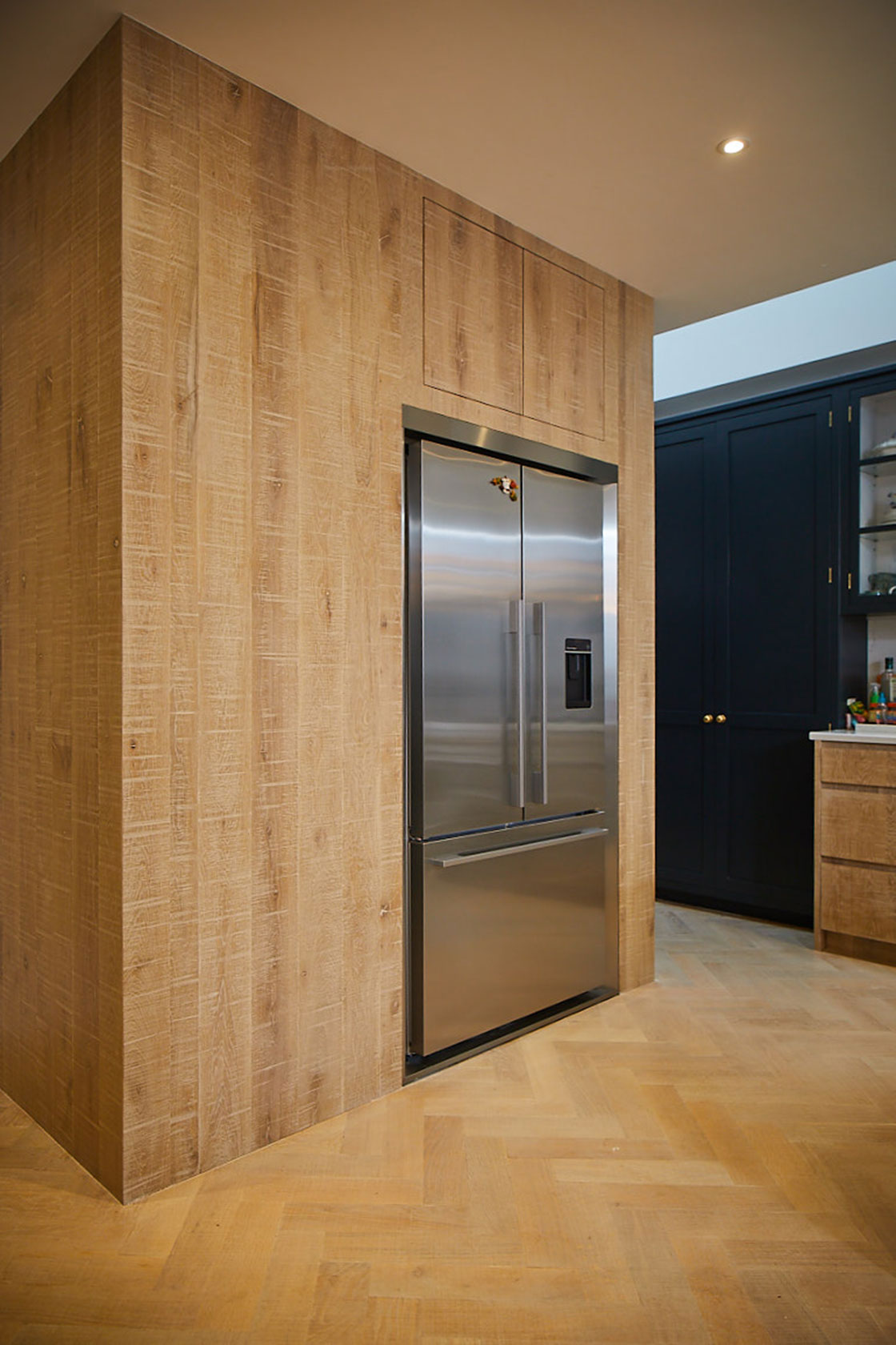 American stainless fridge freezer integrated in to white washed oak kitchen cabinets