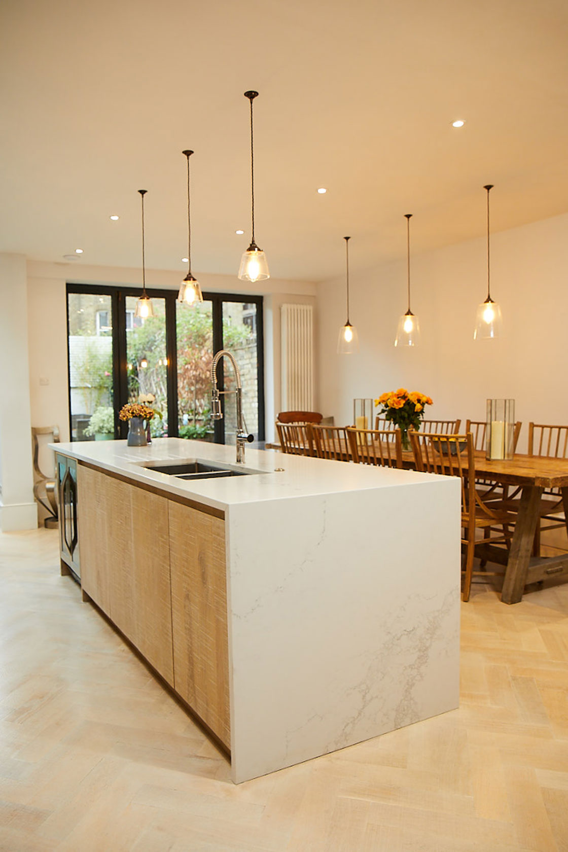 Limed oak engineered slab cabinet doors on kitchen island with quartz Caesarstone white worktop