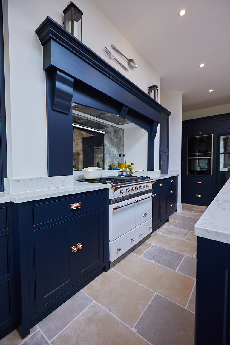 White Macon range cooker by lacanche with dark blue mantle on false chimney breast