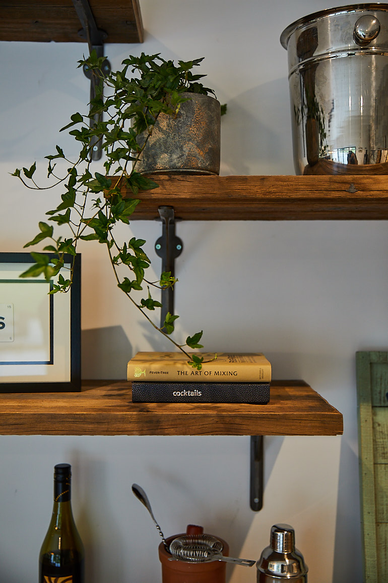 Plants sit on reclaimed shelves on cast brackets