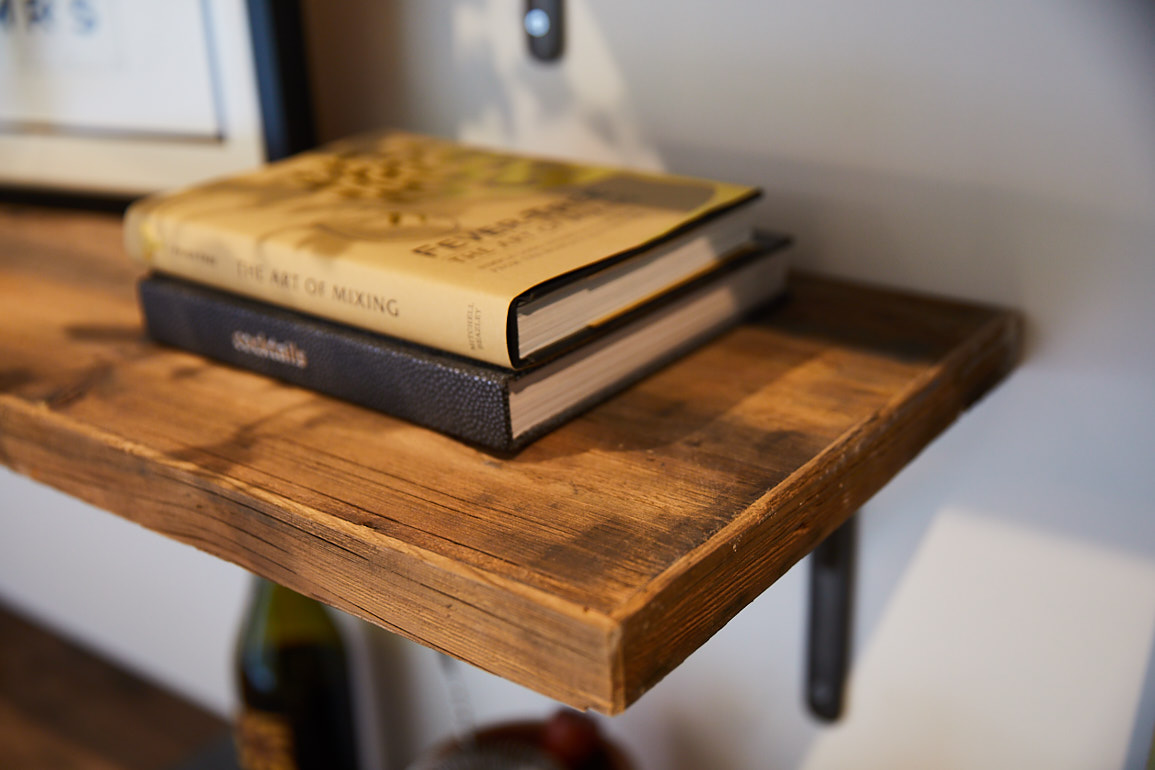 Books rest on reclaimed rustic pine shelf with cast iron bracket