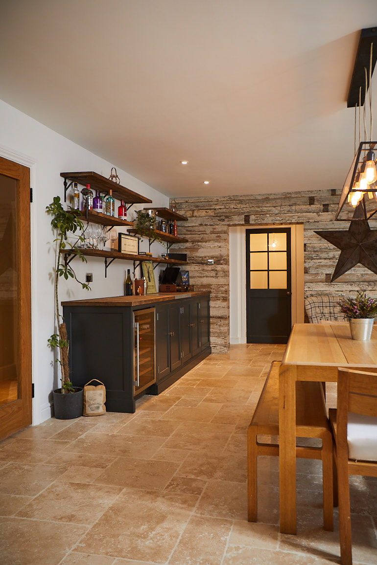 Dark painted drinks units with rustic shelves above