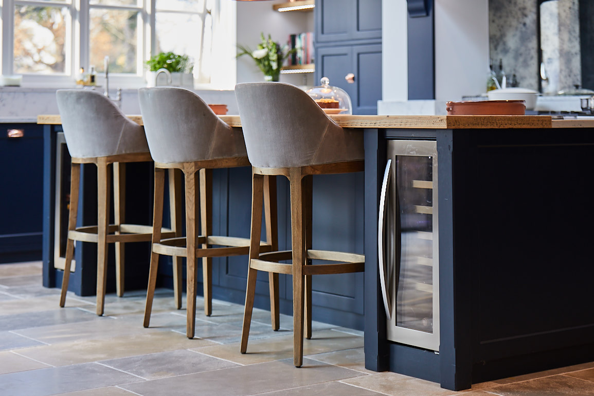 300mm wine cooler semi integrated in to dark blue kitchen island next to bar stools