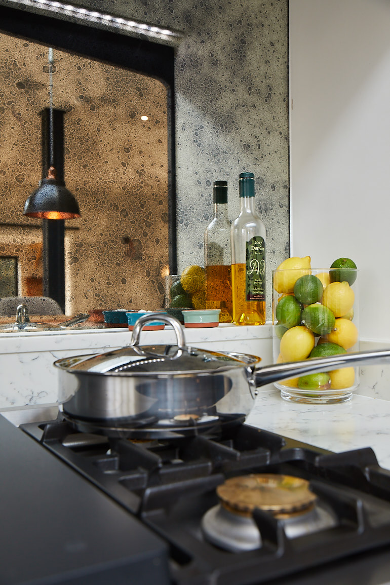 Vintage mirror reflects lemon and limes on gas hob