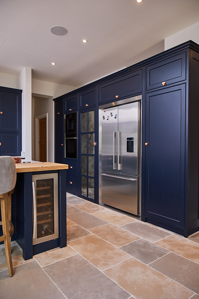 Fisher & Paykel American fridge freezer with surround kit integrated in to large dark blue kitchen cabinets