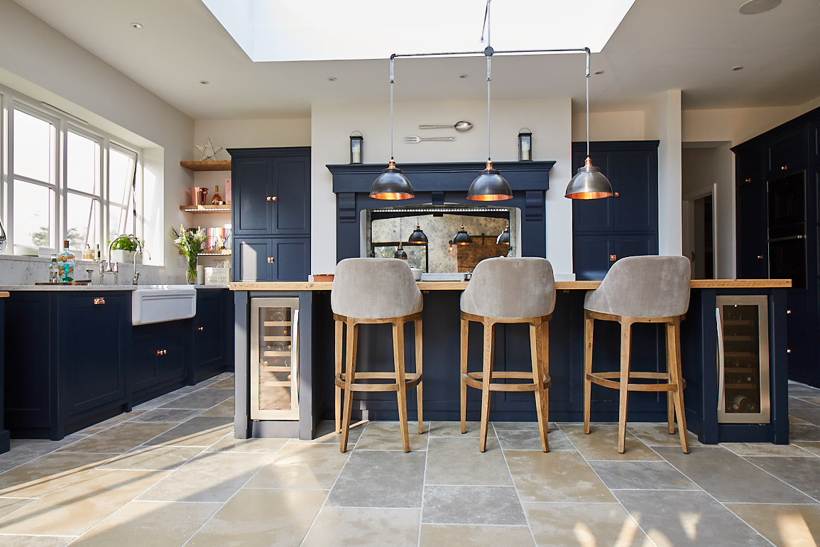 Upholstered bar stools under bespoke kitchen island by The Main Company