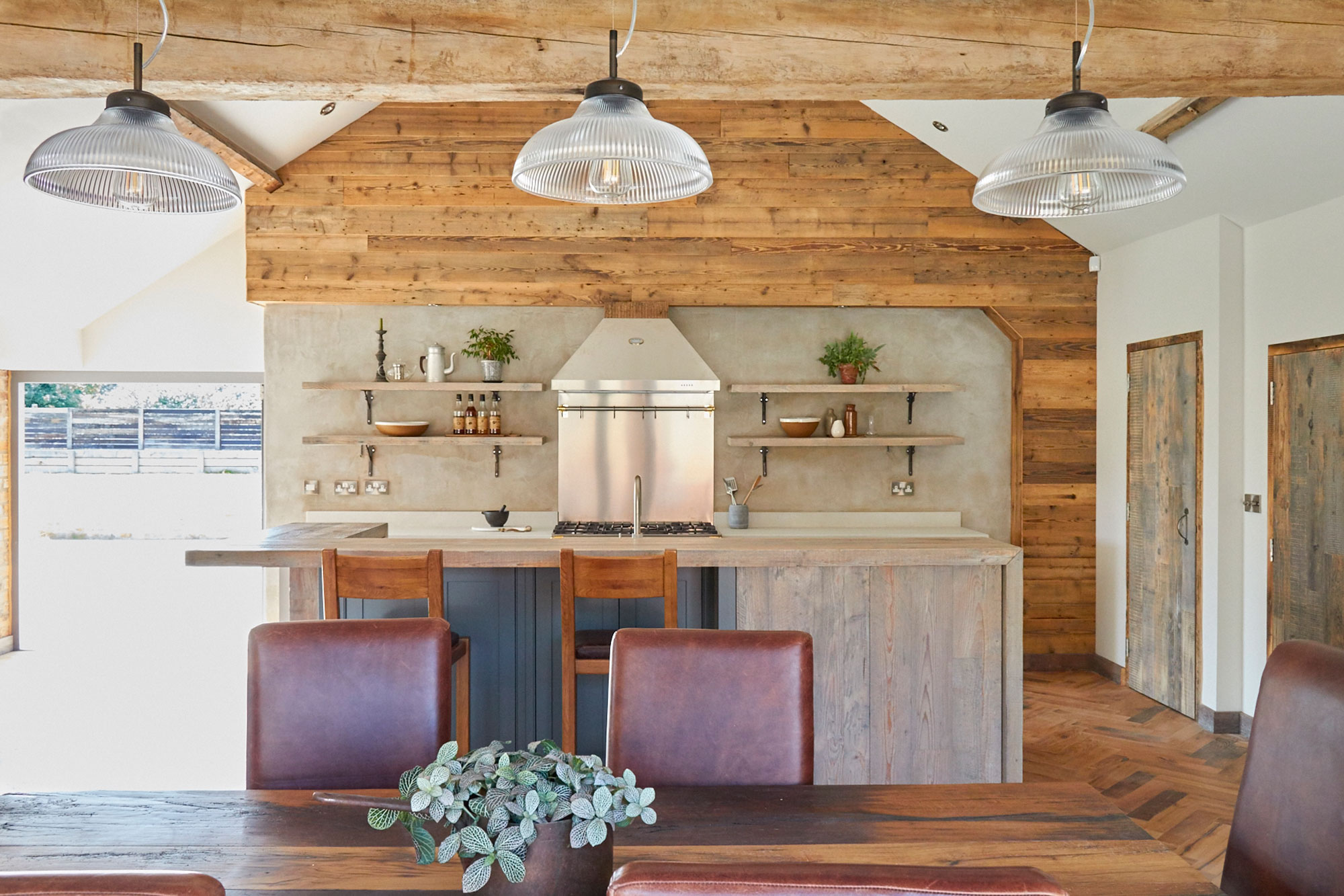 Oak dining table with leather chairs in open plan kitchen