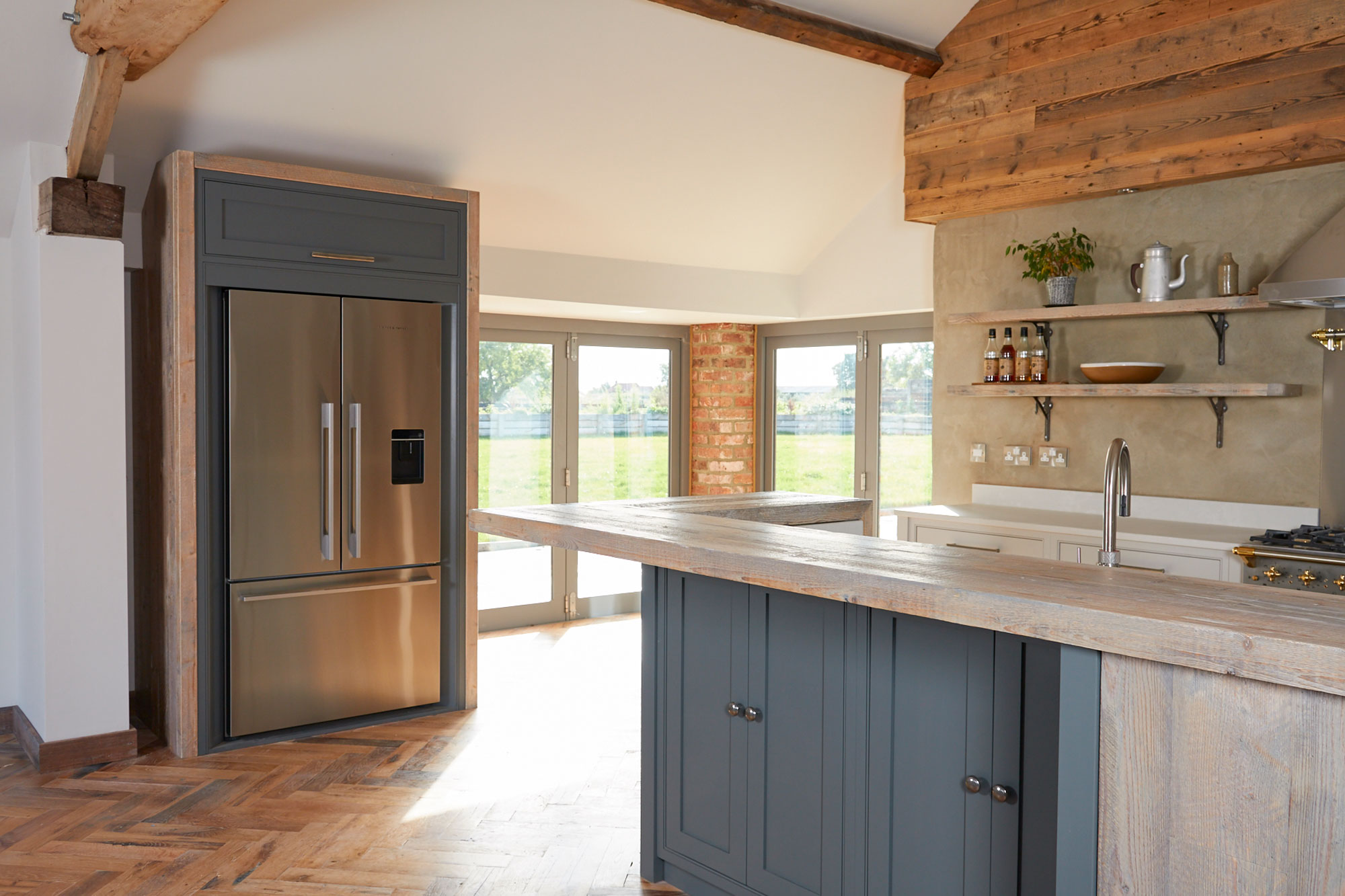 Fisher & Paykel American fridge freezer integrated in to painted unit with rustic oak posts