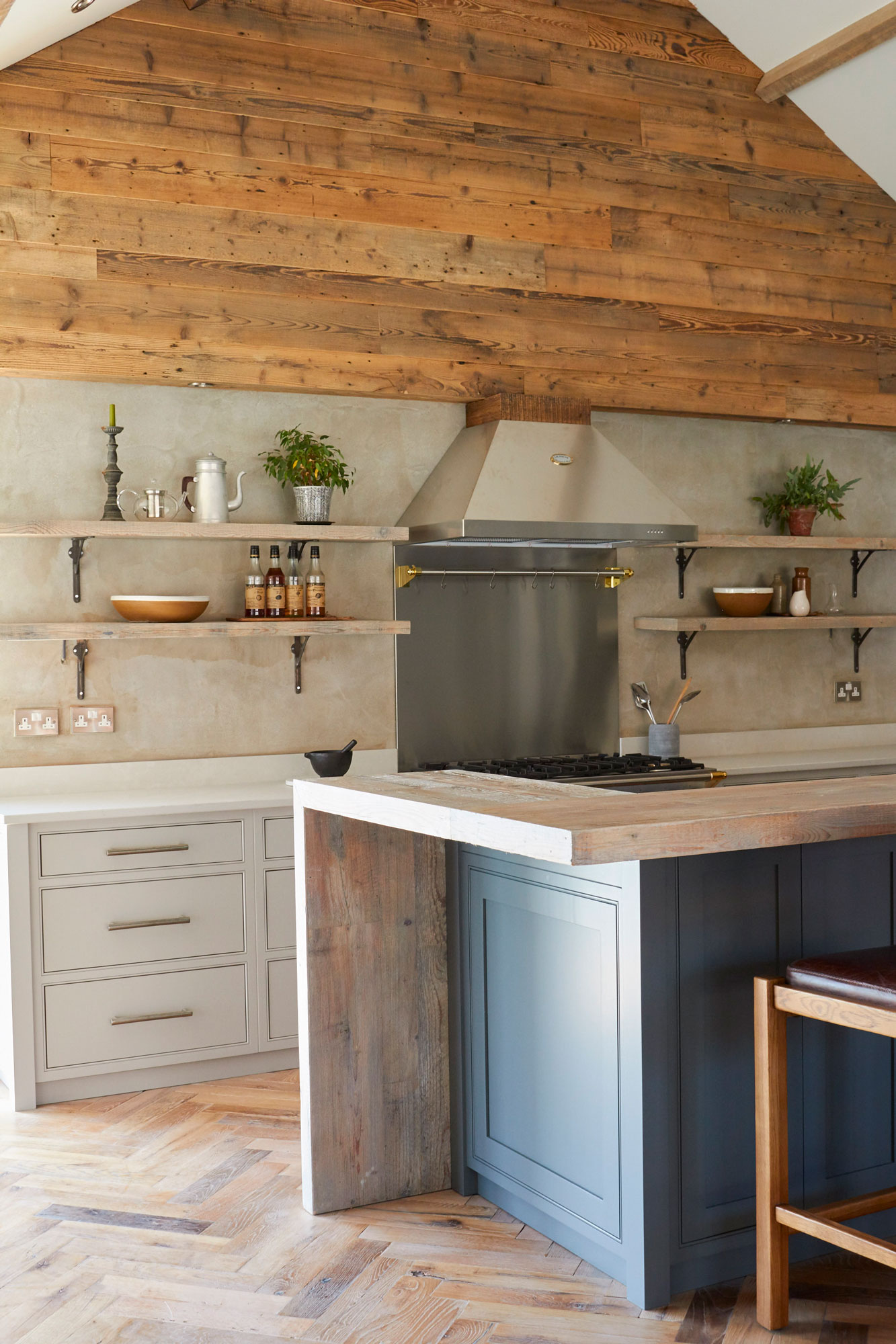Painted kitchen with herringbone oak floor and cladded reclaimed wood wall