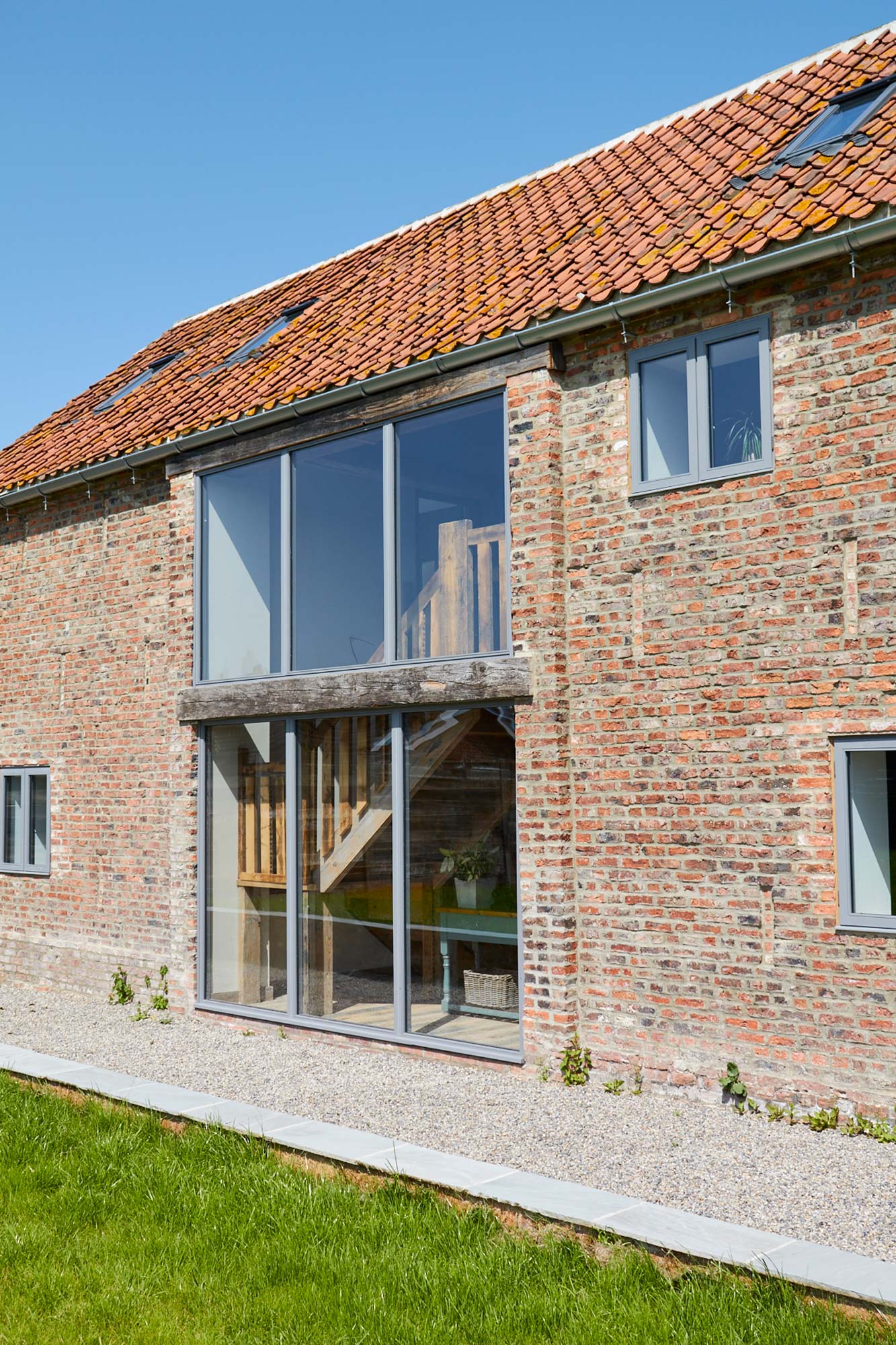 Large glass windows on red brick barn building