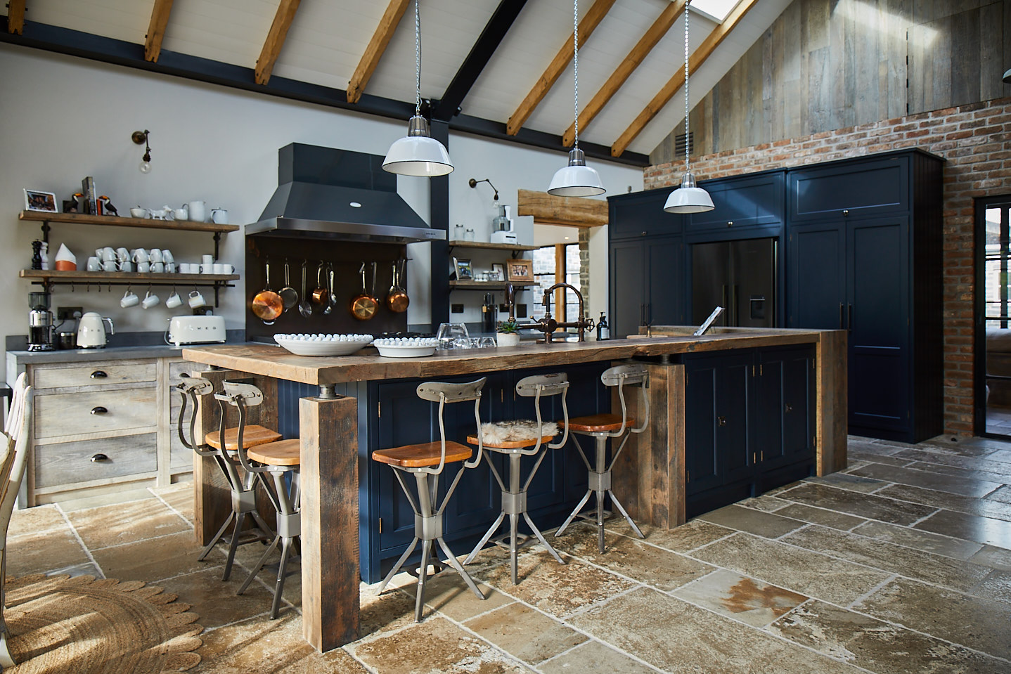 Large reclaimed kitchen island with metal bar stools