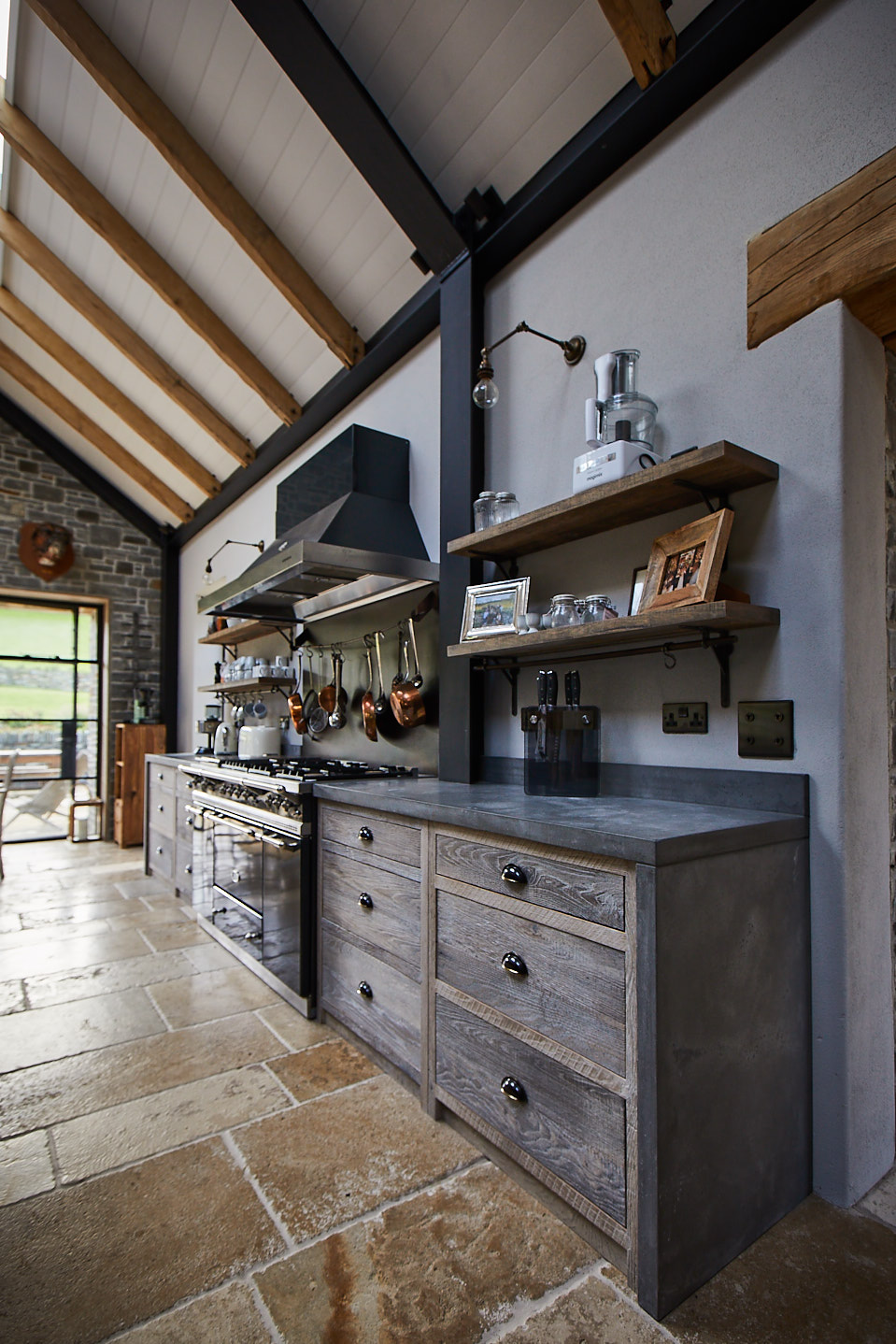 Lacanche range with rustic oak pan drawers and solid concrete kitchen worktop