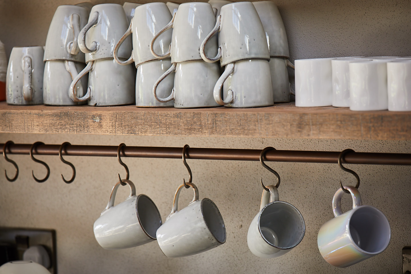 Engineered rustic shelf with white mugs and hanging rail with little metal hooks