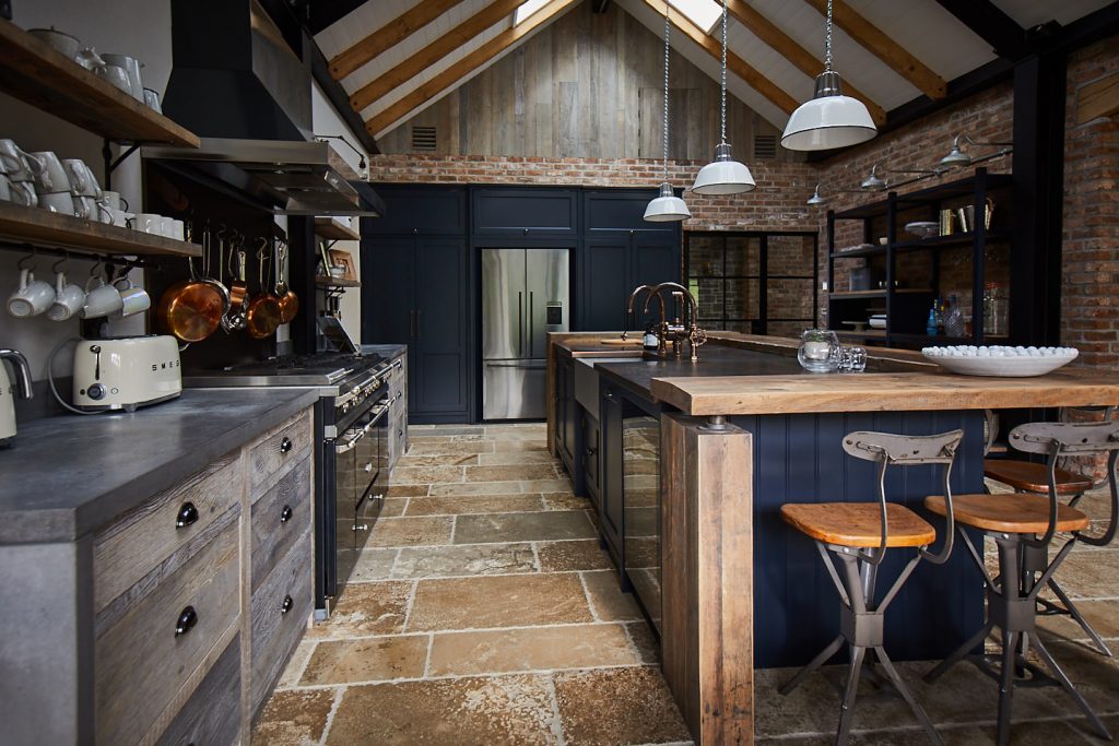 Reclaimed kitchen with dark blue units and oak breakfast bar