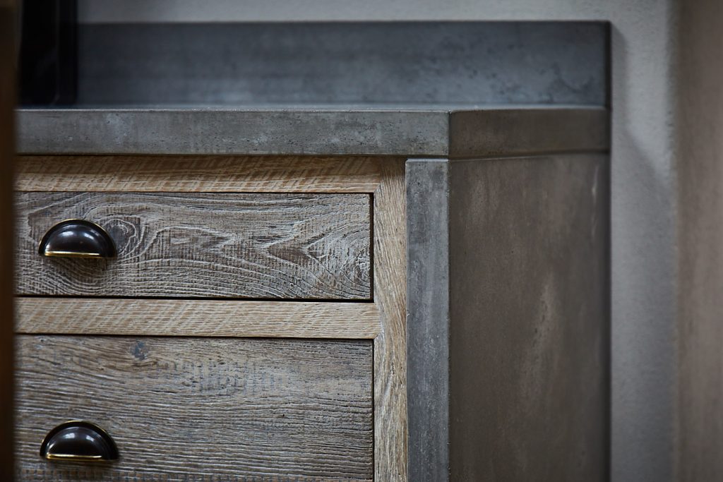 Solid concrete worktops on pan drawers with waterfall sides