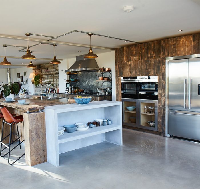 Large bespoke kitchen island with concrete storage and reclaimed oak breakfast bar