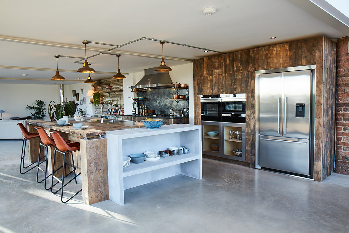 Large bespoke kitchen island with concrete storage and reclaimed oak breakfast bar