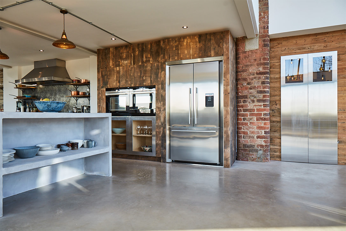 American stainless steel fridge freezer inset in bespoke kitchen units reclaimed from rustic pine oak